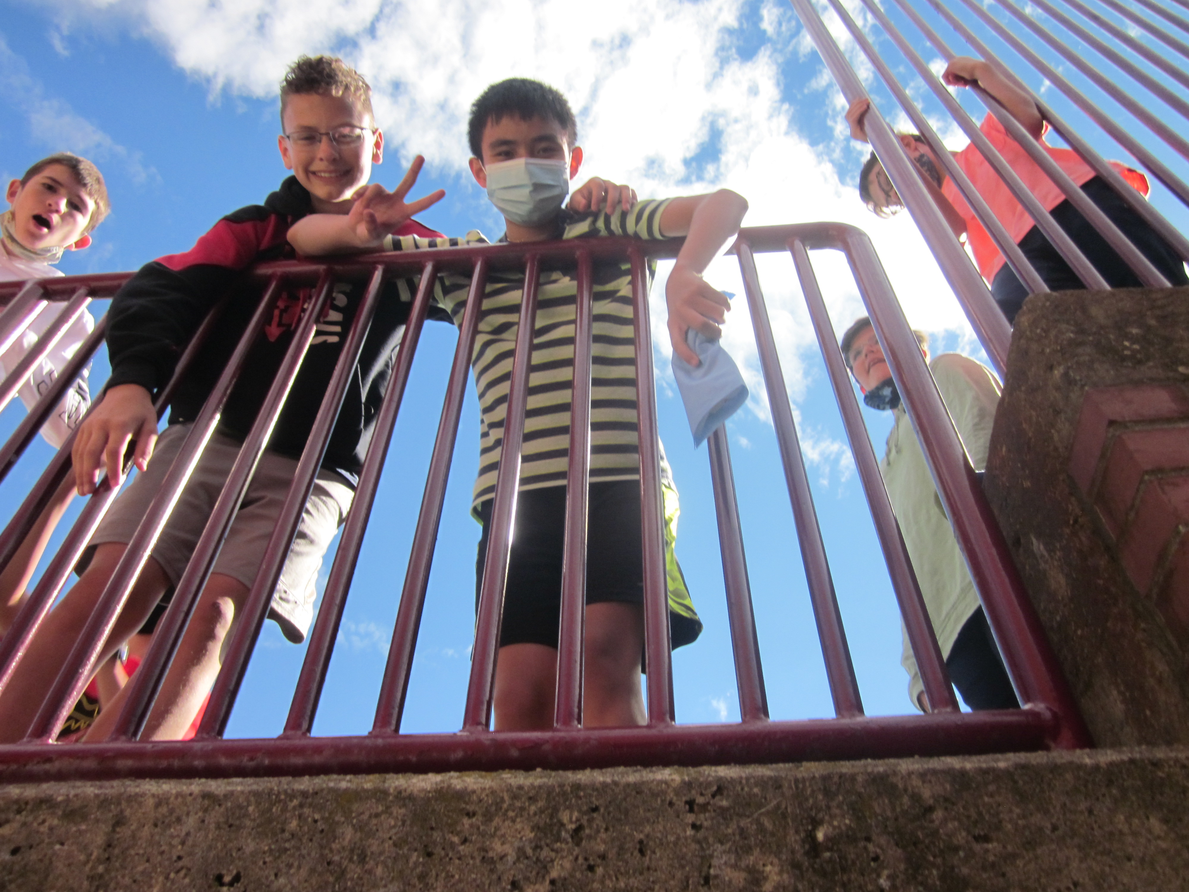 students smile and wave during lunch outside in the back of the school