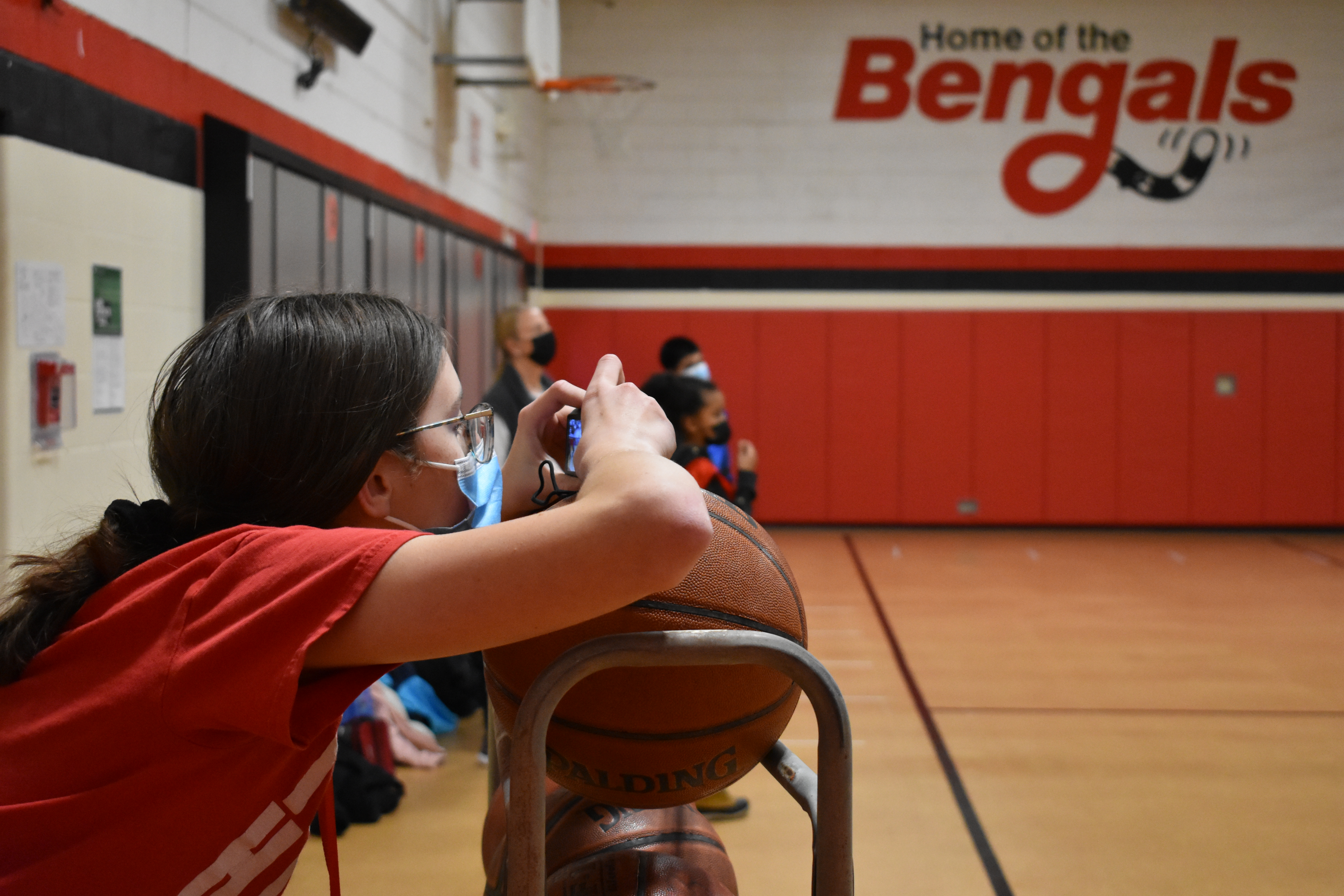 yearbook club member takes a picture of intramurals in the small gym