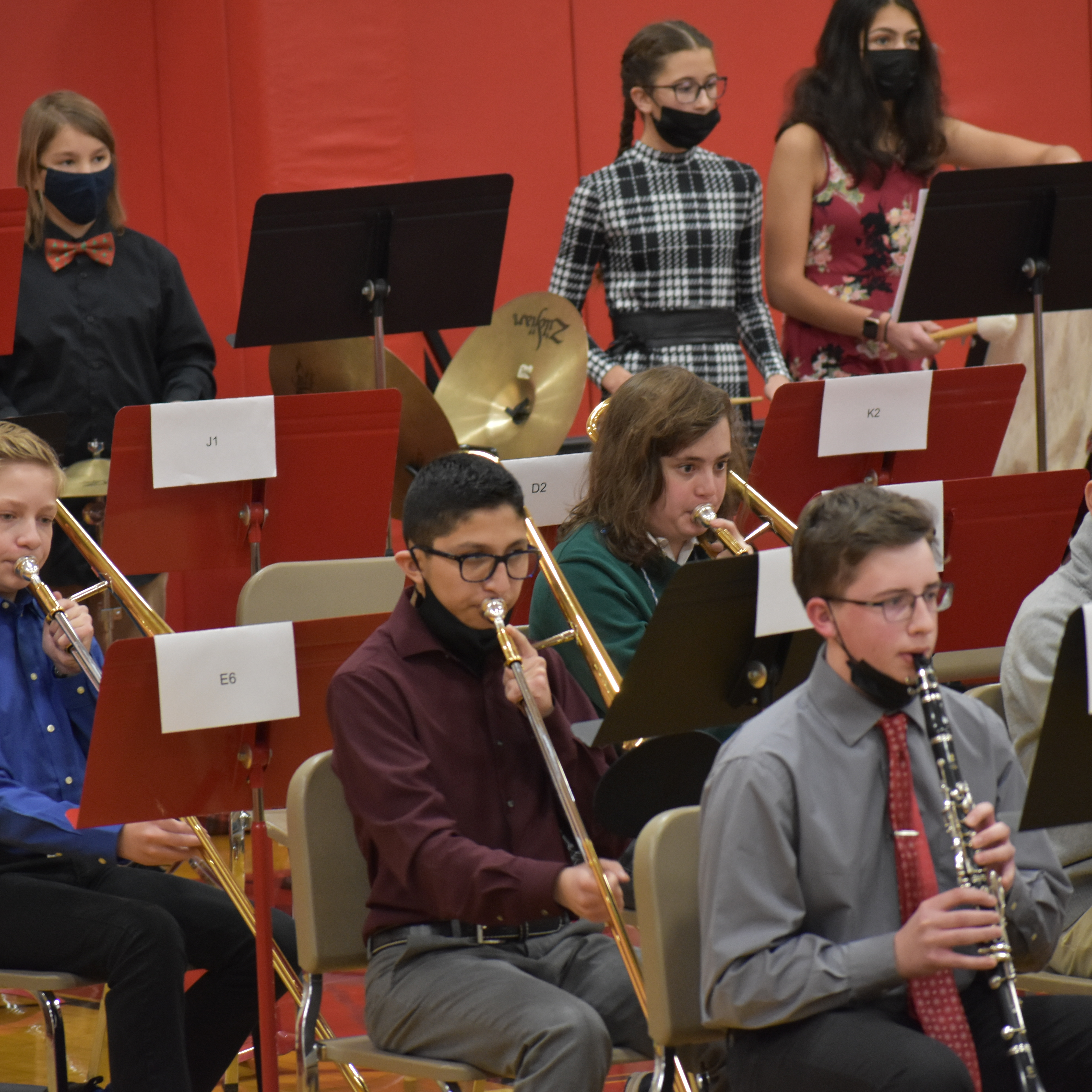 Band members playing during a concert - clarinets and trombones in the foreground