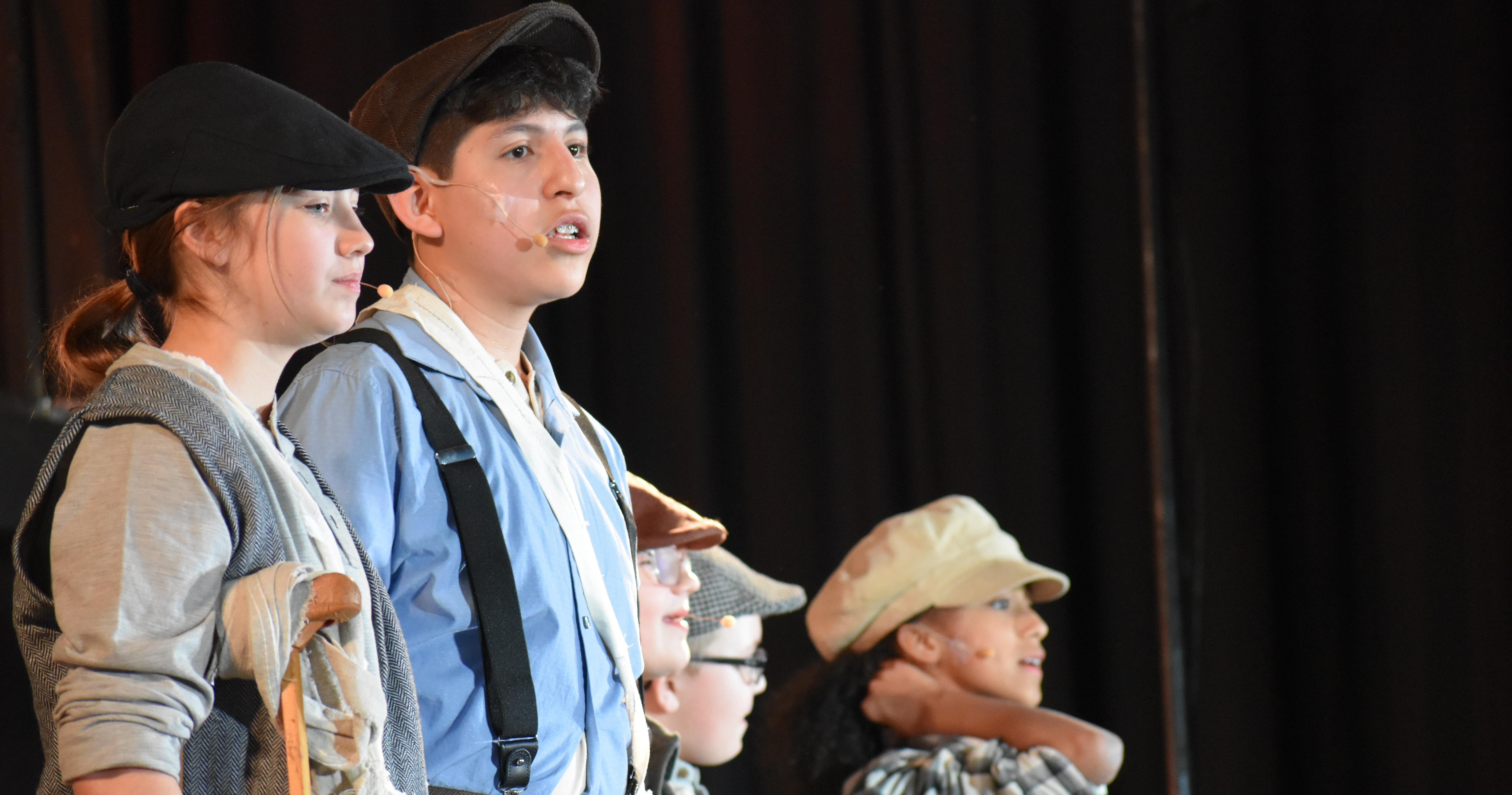Three students perform on stage for the BMS musical, Newsies