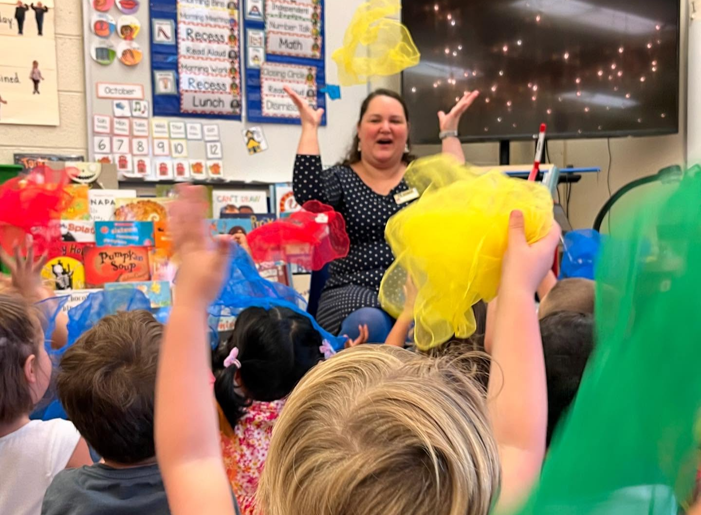 BTF teacher throwing scarf in the air infront of her class as they copy her