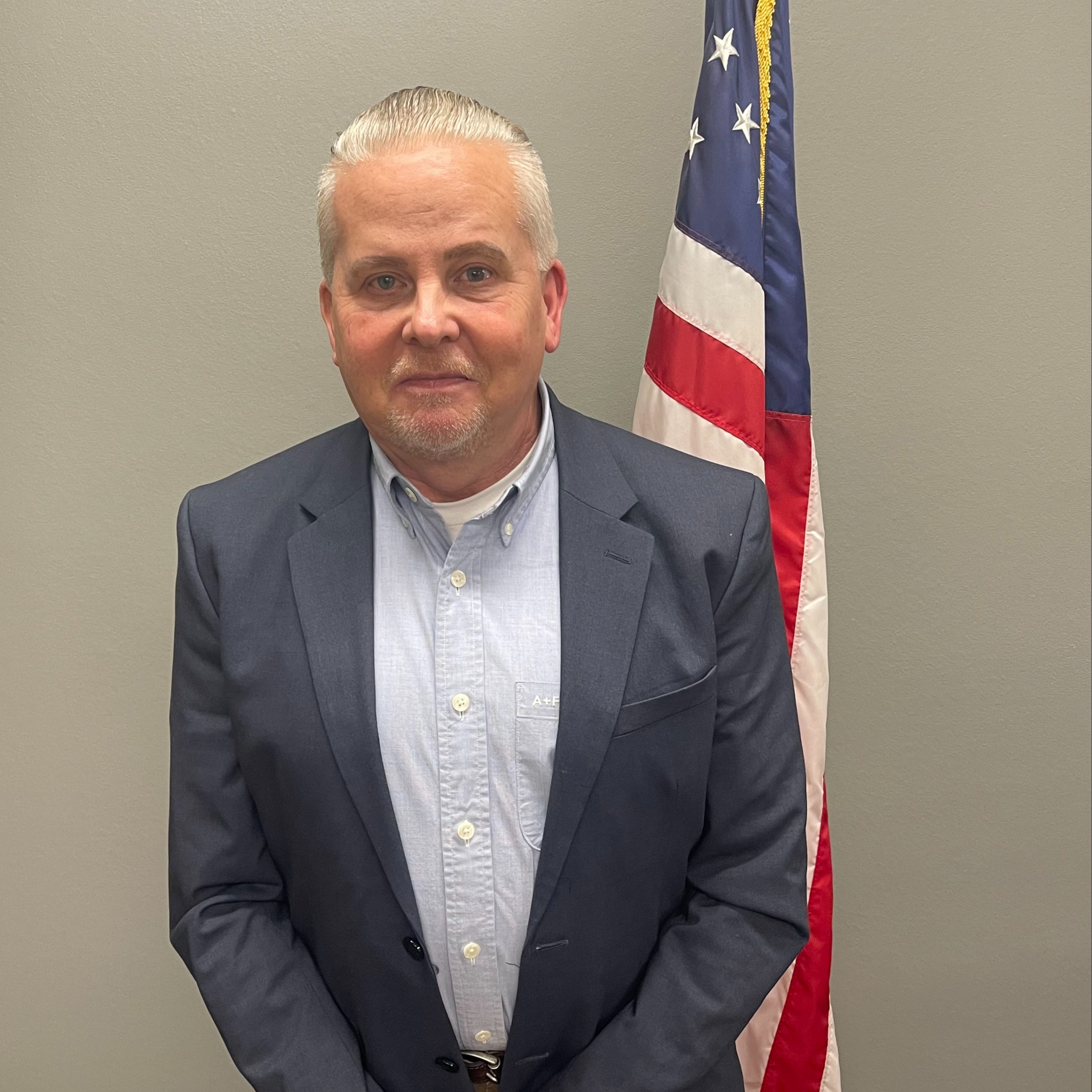 Scott Mason standing next to american flag