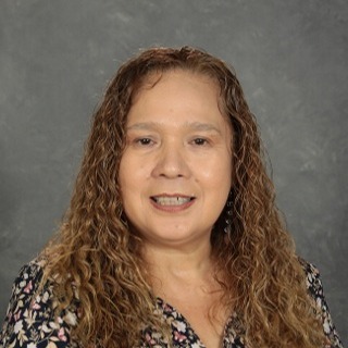 Staff member headshot with a grey background.