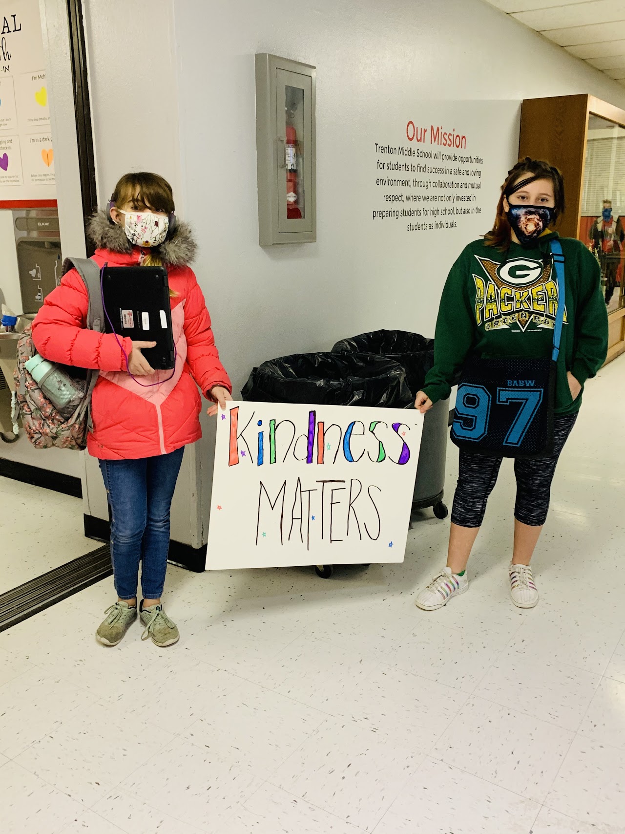 Two students next to each other holding a sign that says kindness matters