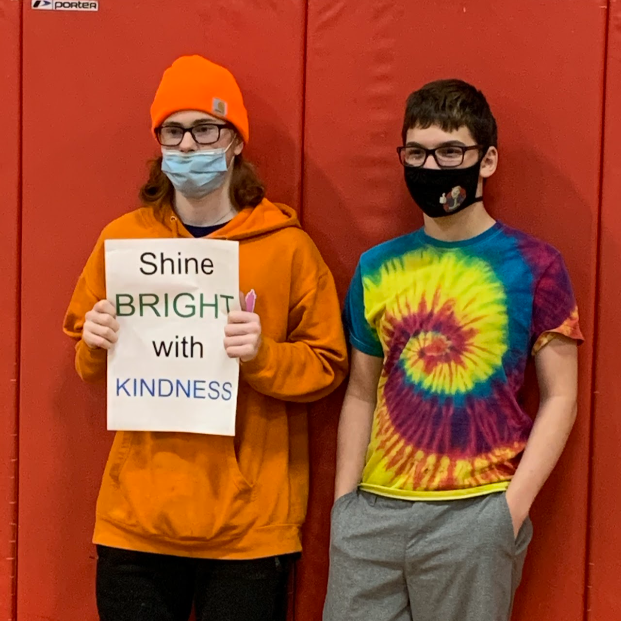 Two students next to each other with a sign that says shine bright with kindness