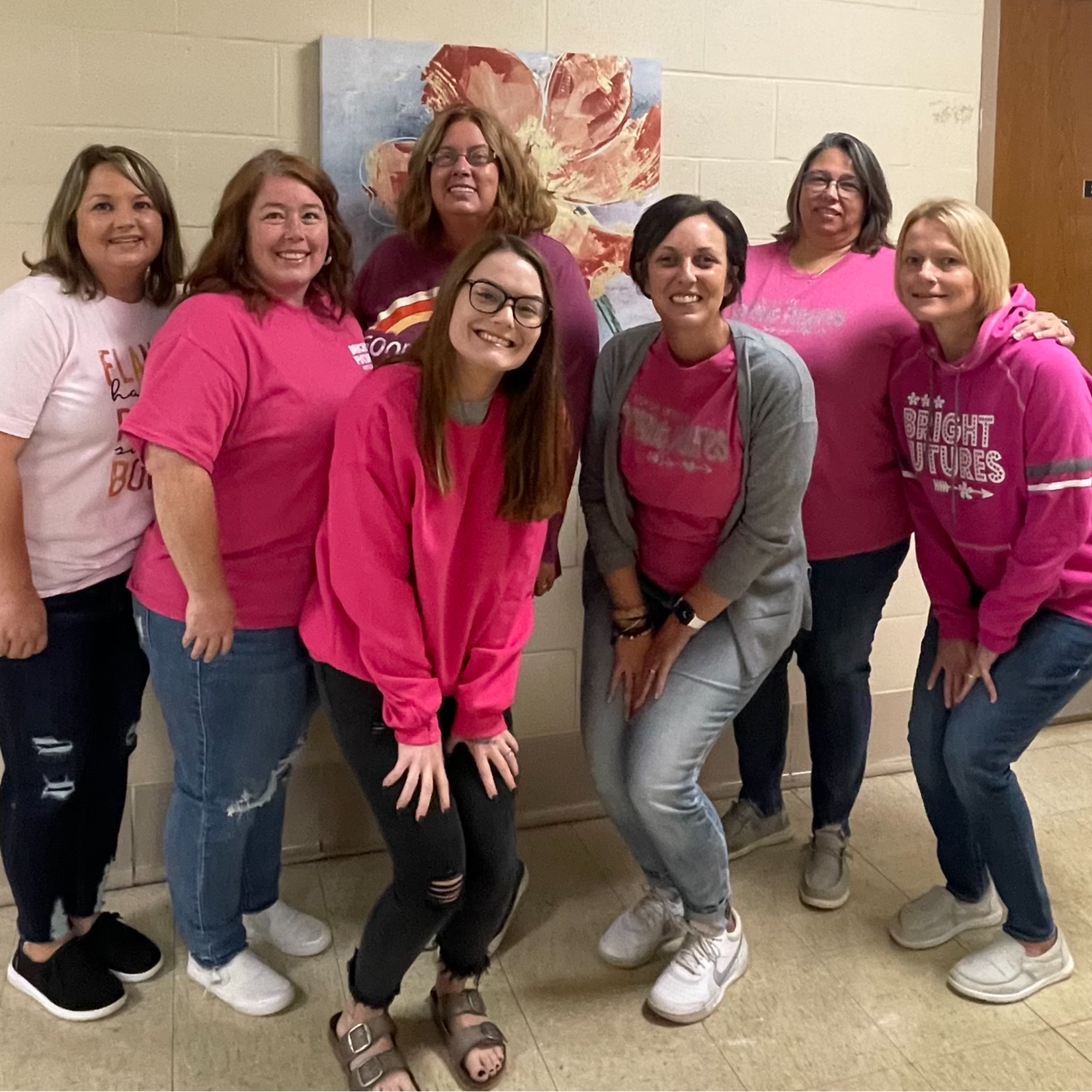 Bright Futures staff pose in the office hallway, in pink shirts, to show support of Journee Vinyard