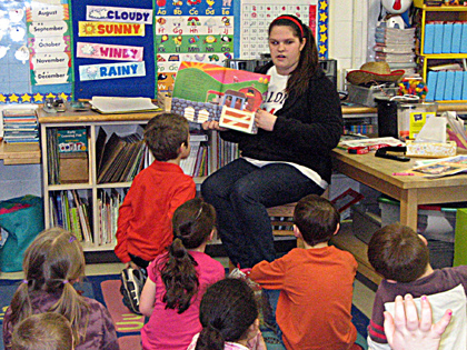 An Early Childhood Program student reads to a kindergarten class in a local elementary school.  