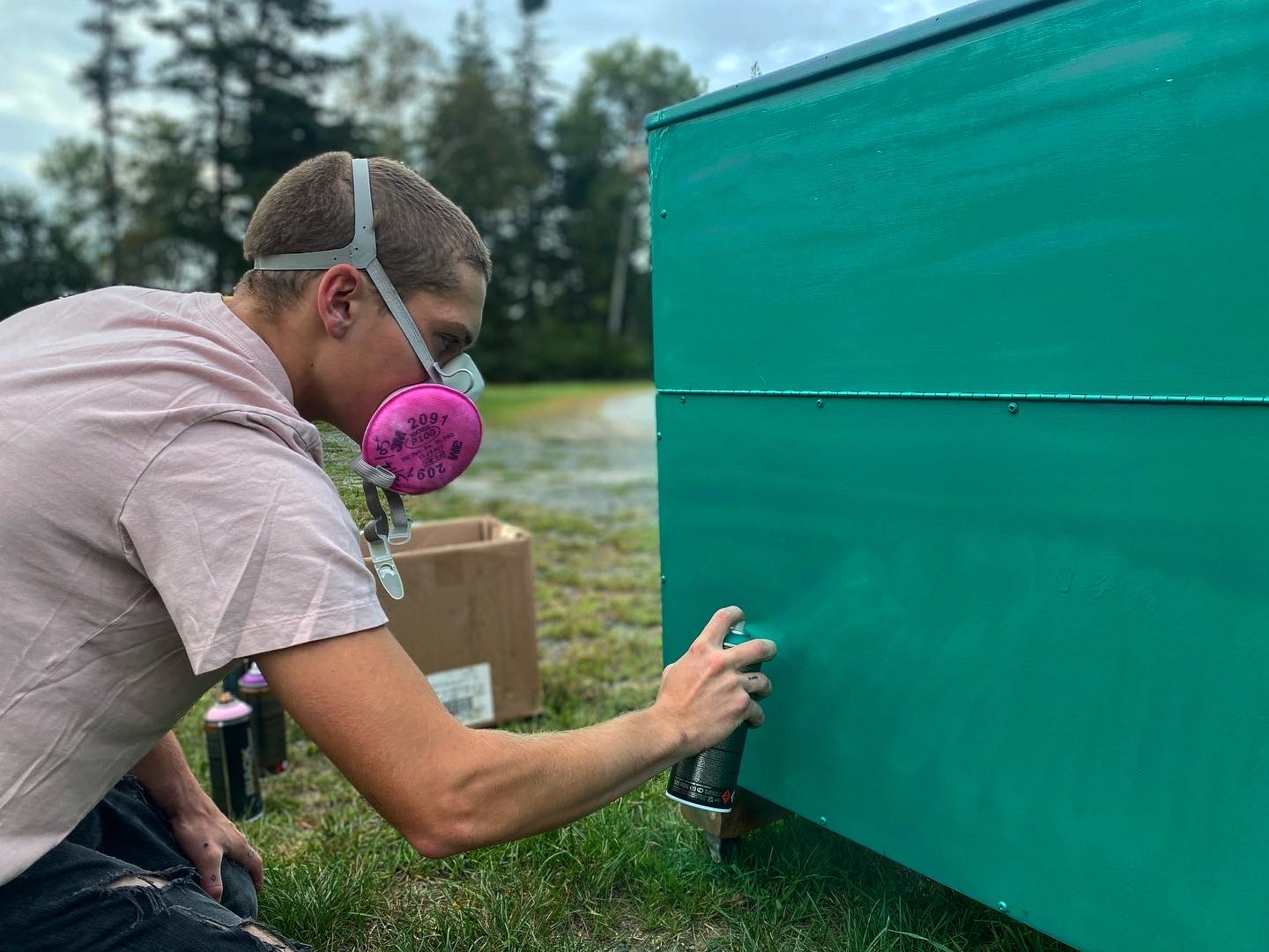 Student spray painting a cart