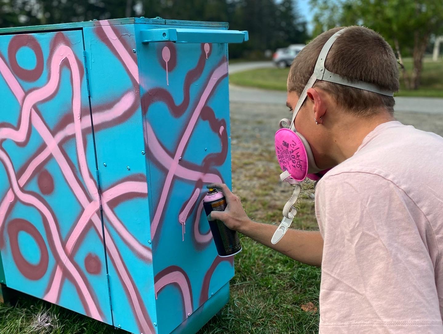 Student spray painting a cart