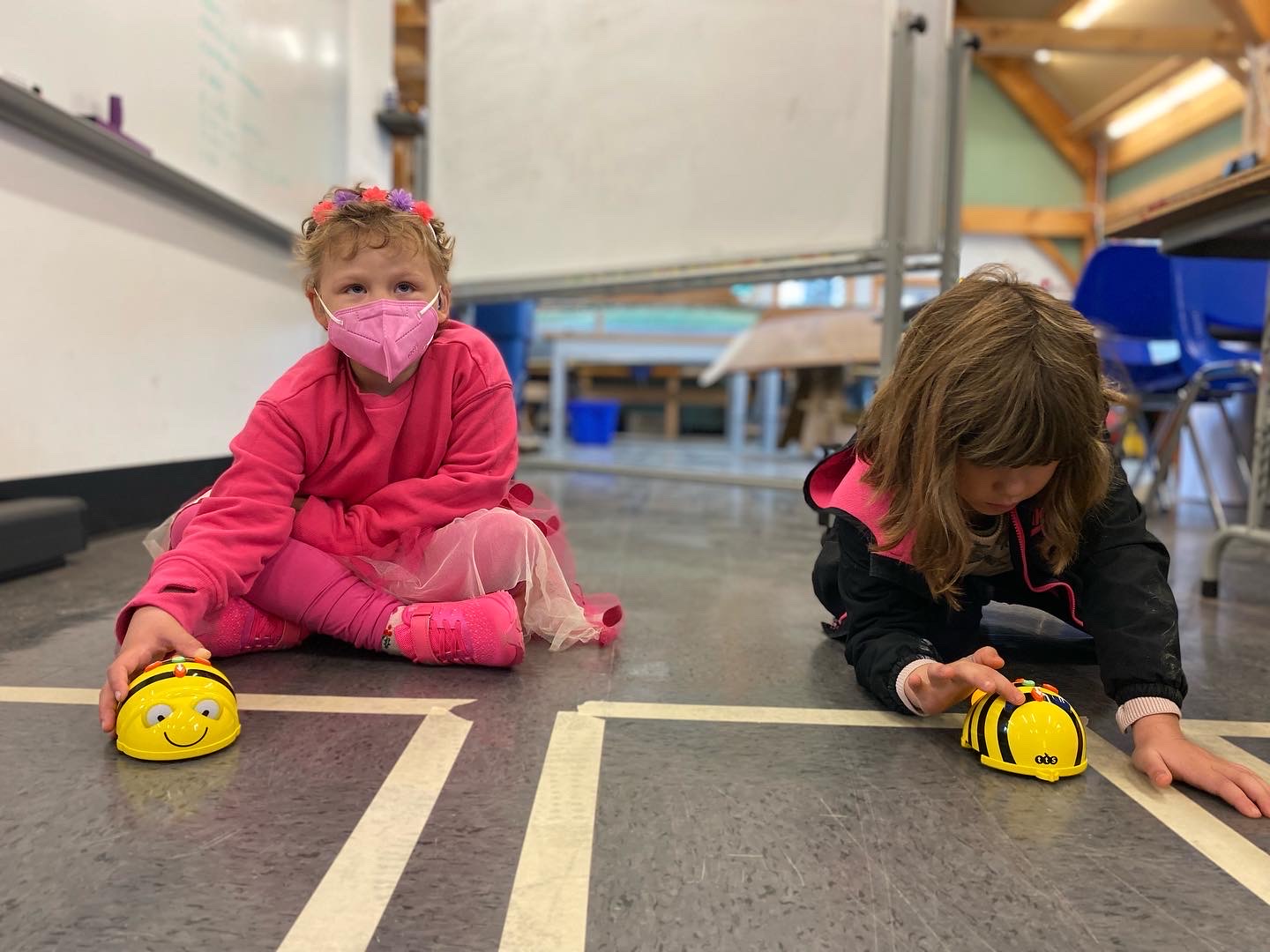 two students working in their square with their bee bots