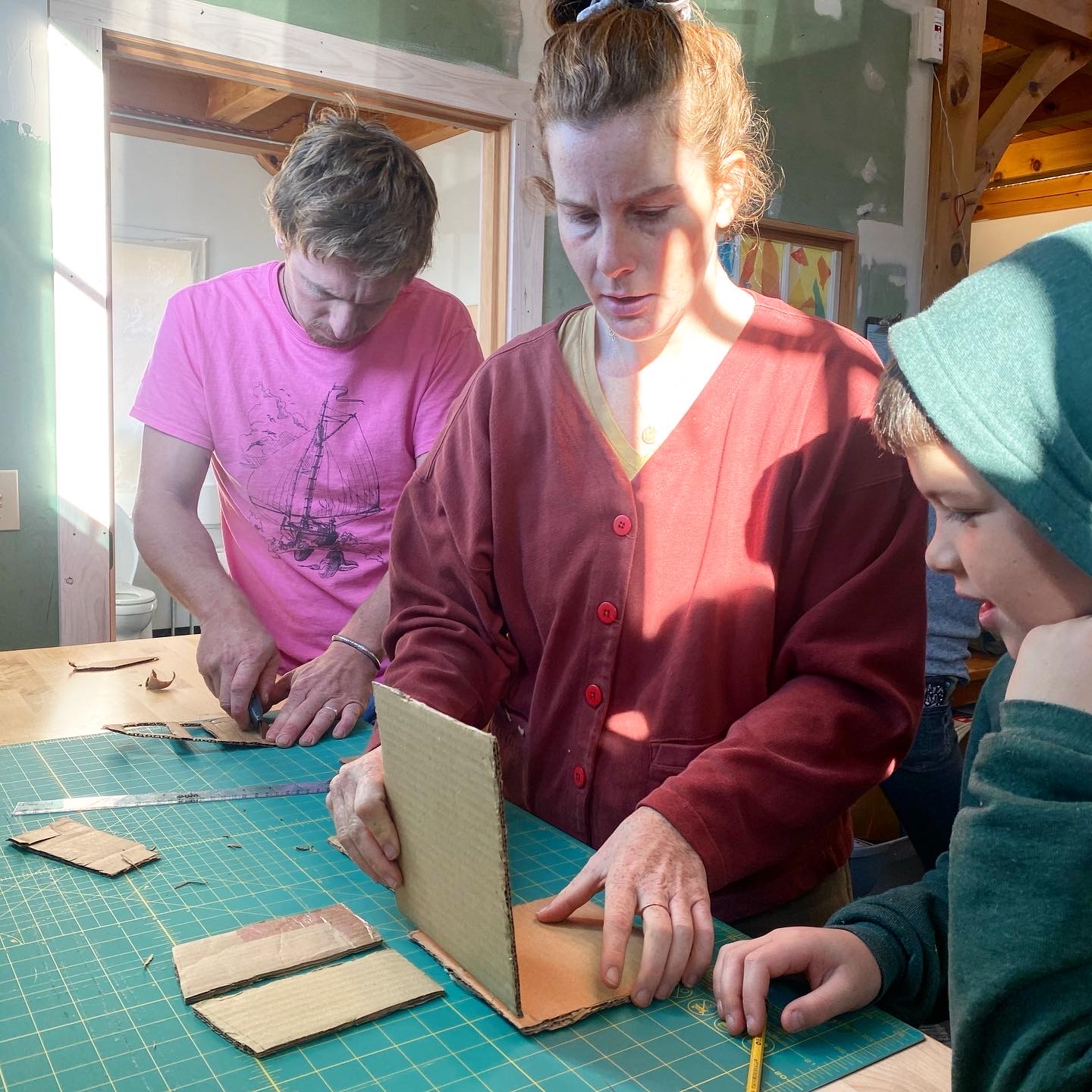 two teachers helping a student with the x-acto