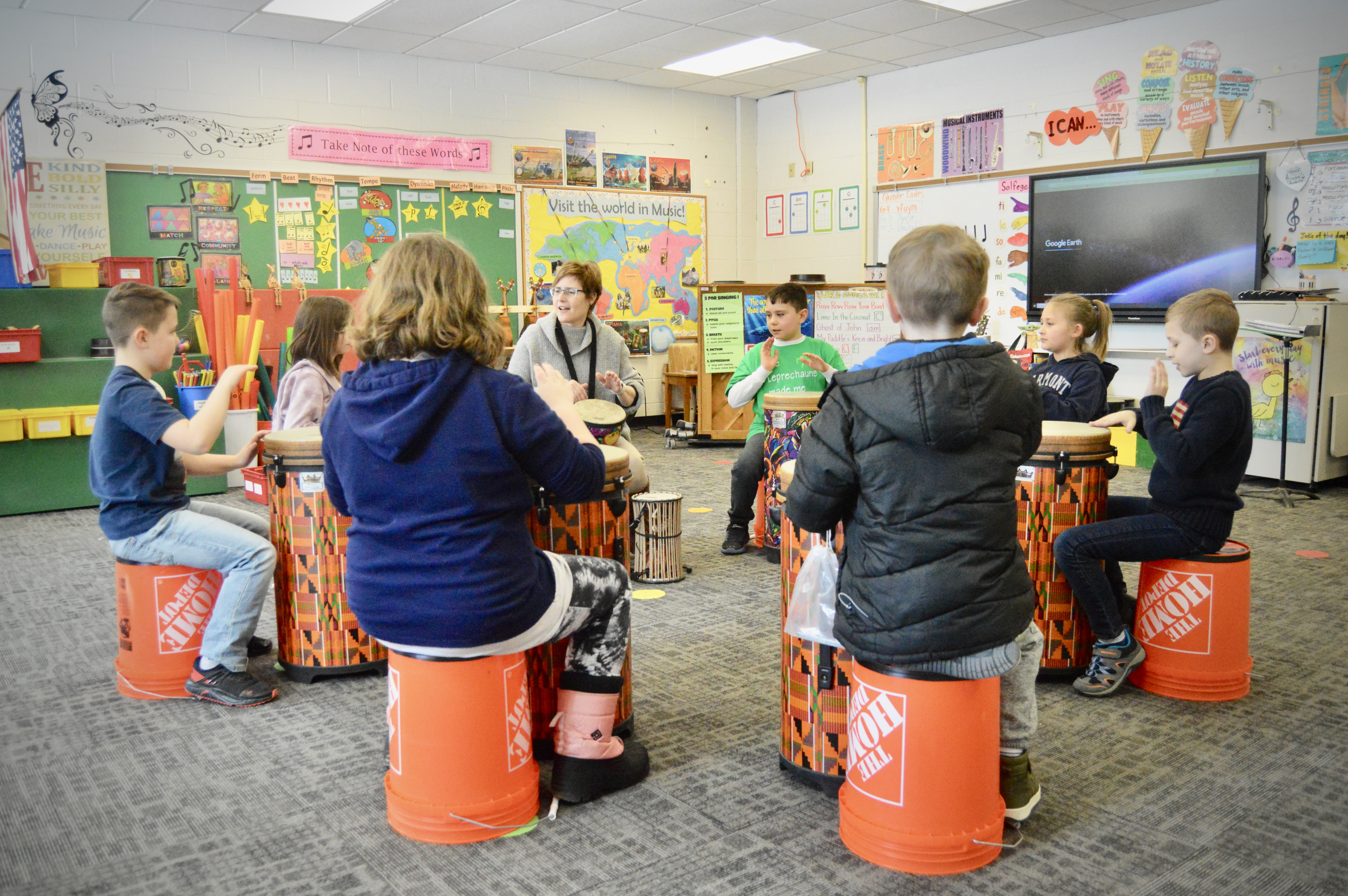 Students learning to drum in a circle