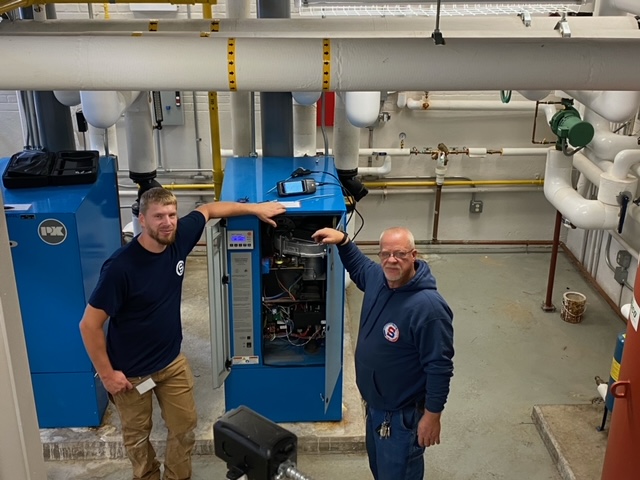 Dave Dutcher and Eric Szady, HVAC workers, running a diagnostic test on a high efficiency condensing boiler at Keane Elementary.
