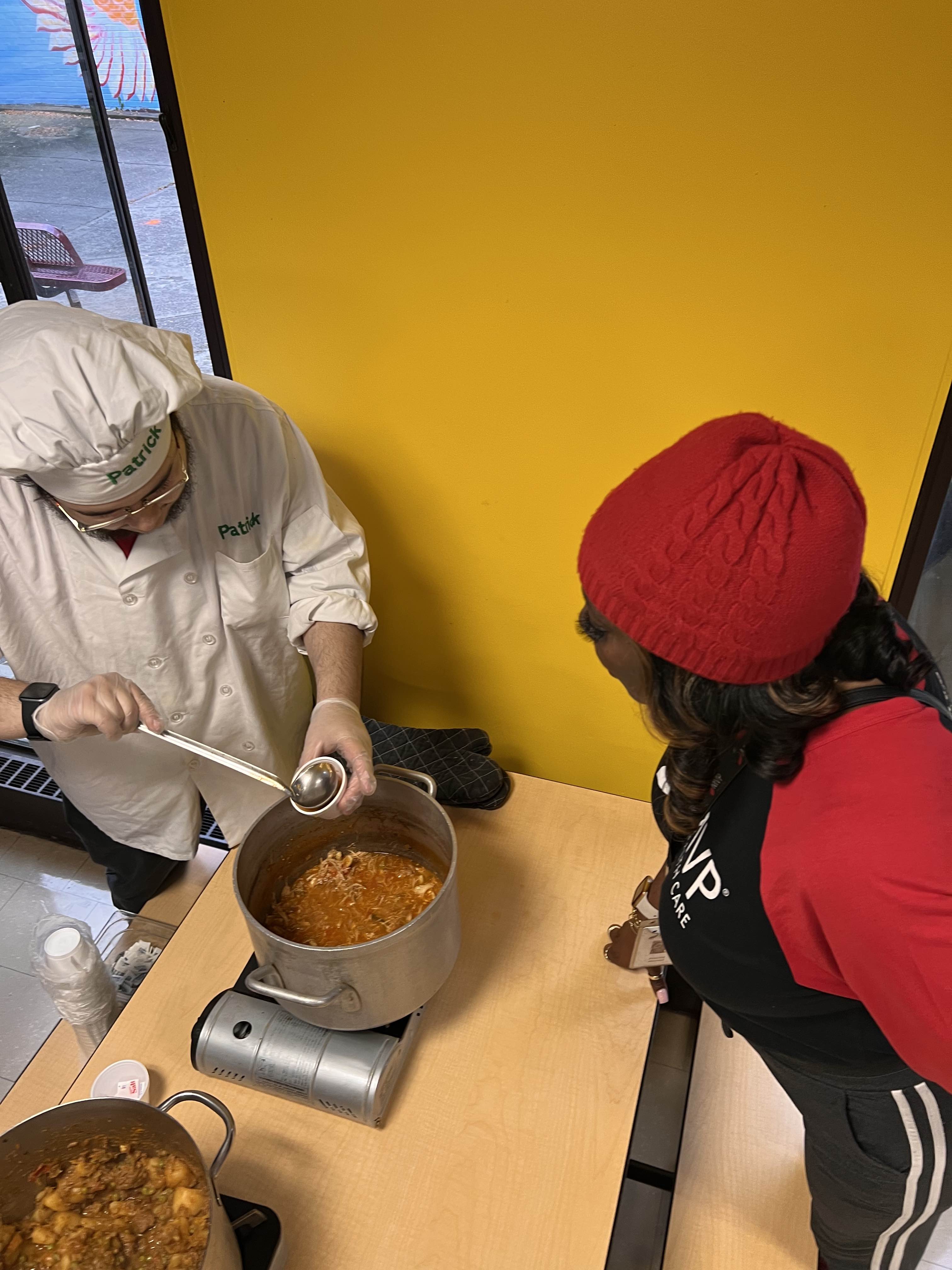 Students serves stew to another student
