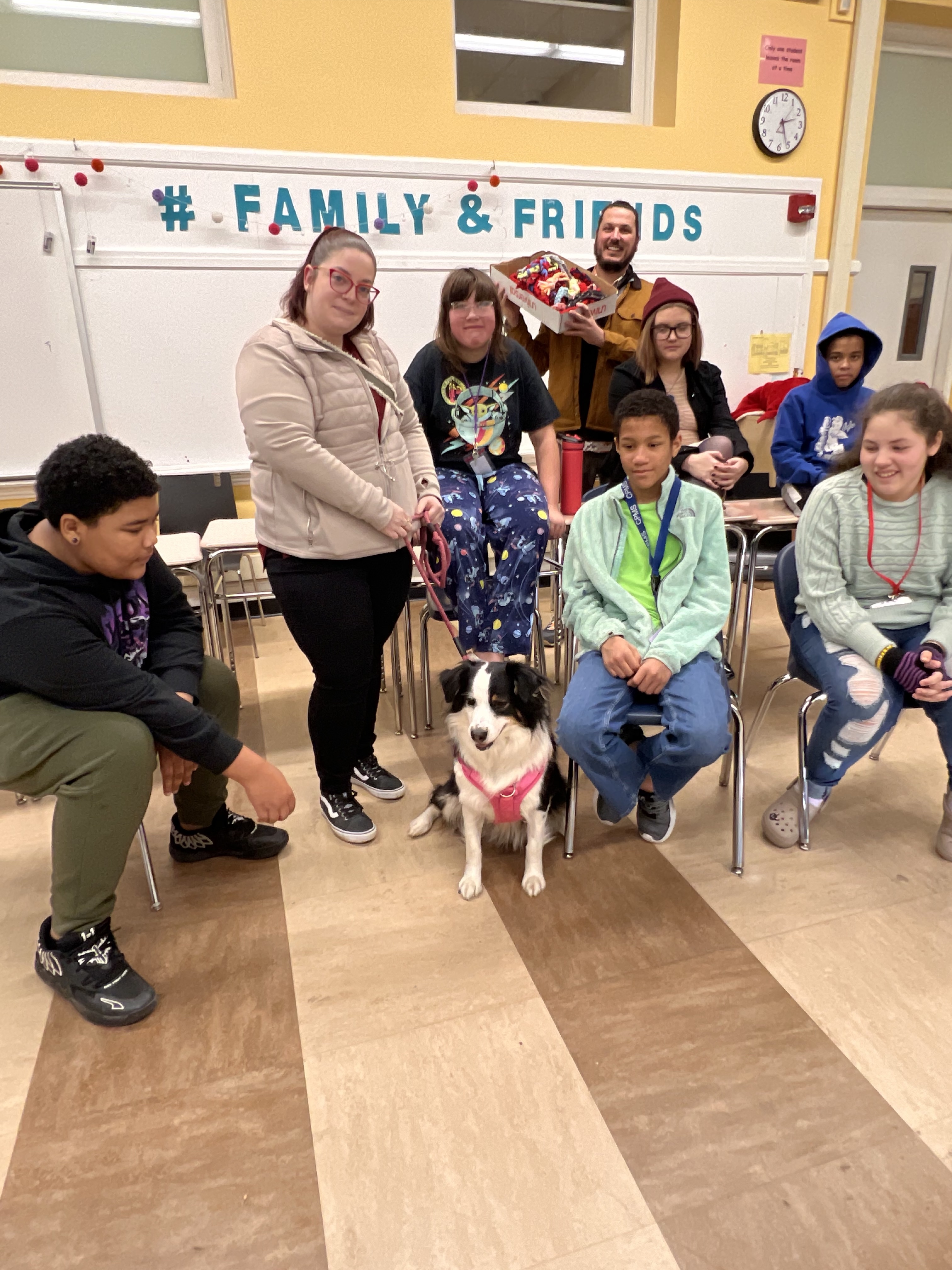Group of students with shelter dog and homemade toys