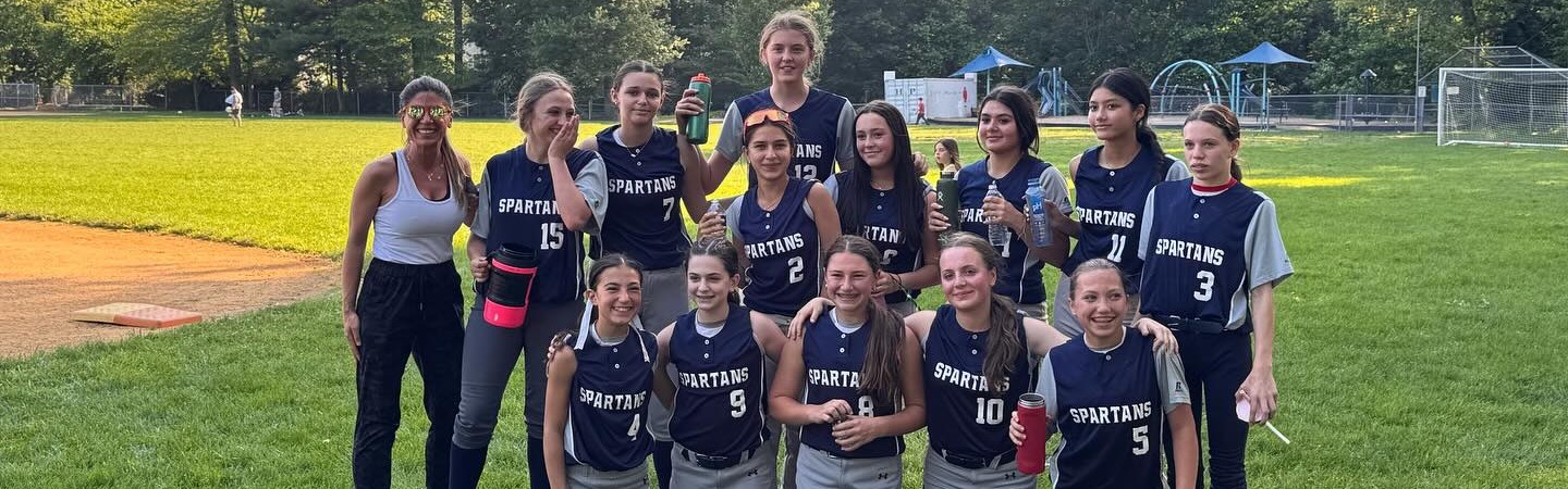 Harrington park softball players with Ms. Pasi, Ms. Pabst, and Ms. Saccoccio on the Softball Field behind Harrington Park SchoolI