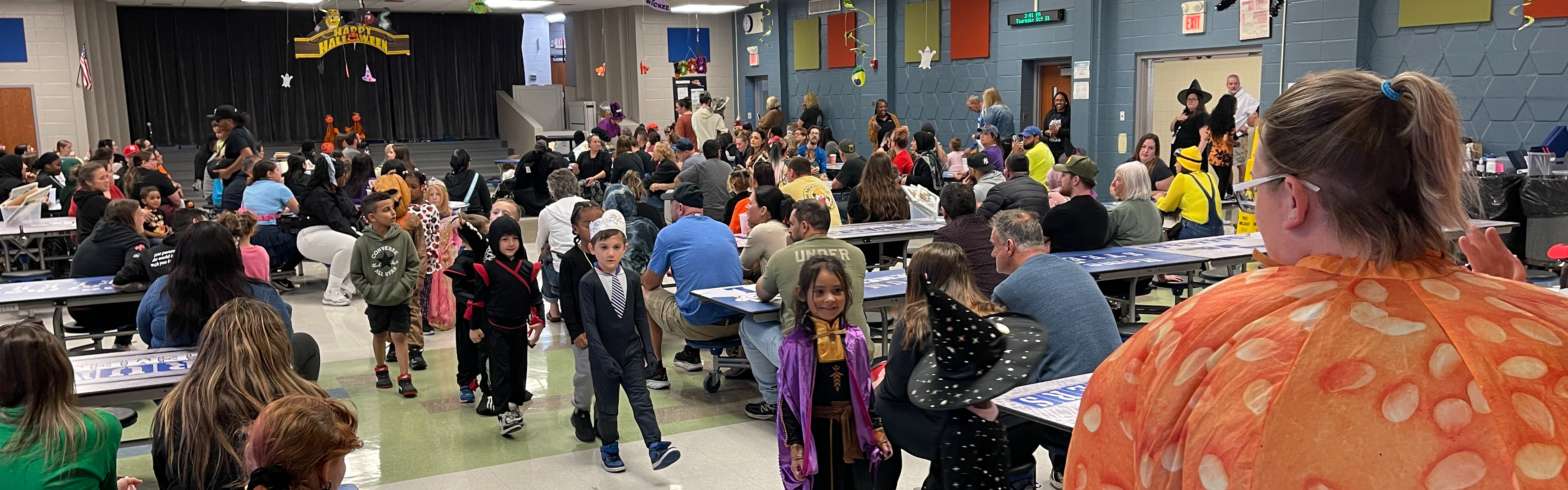 Students walk through the cafeteria through Halloween parade.