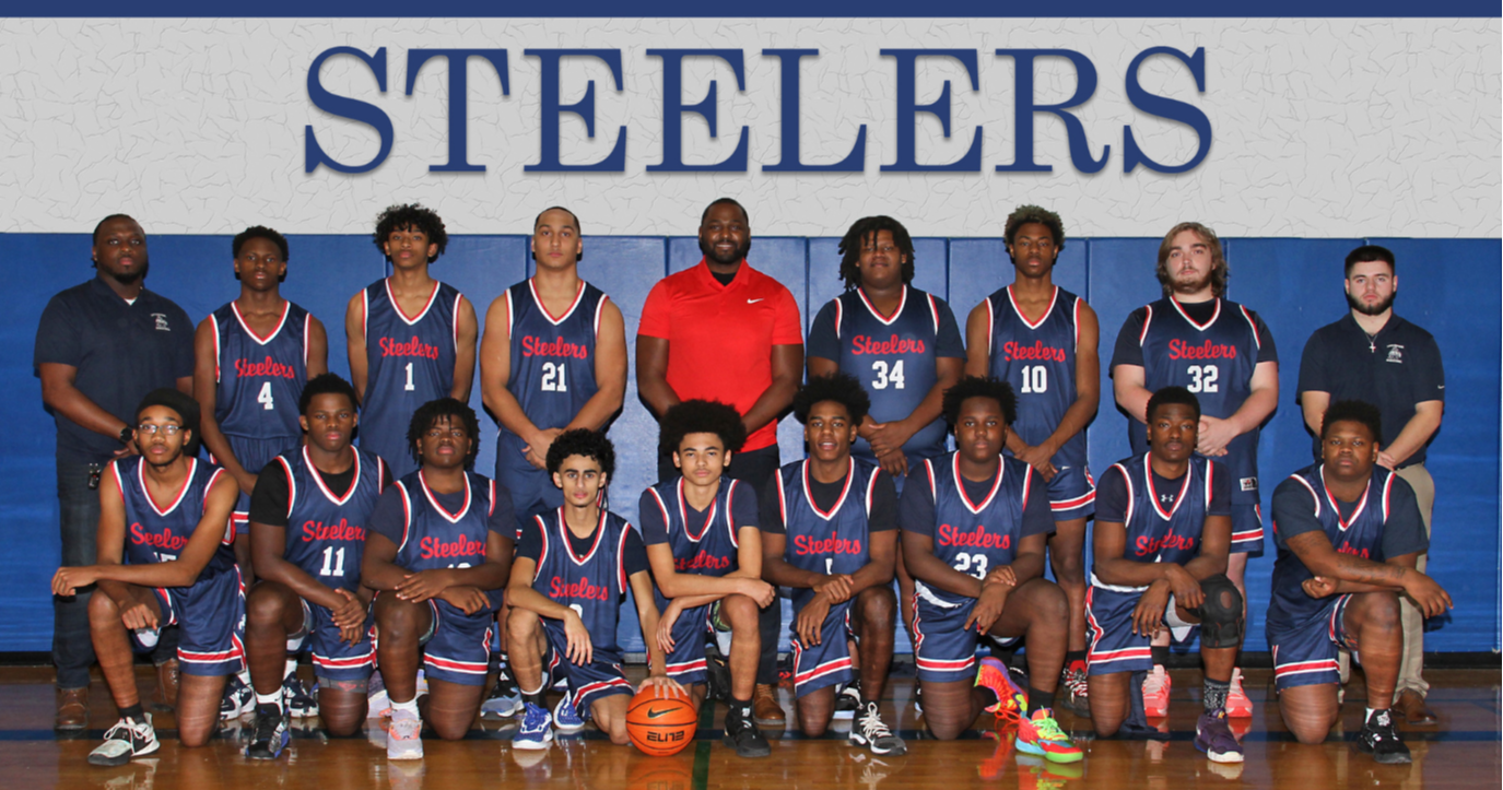 Basketball team poses in uniform.
