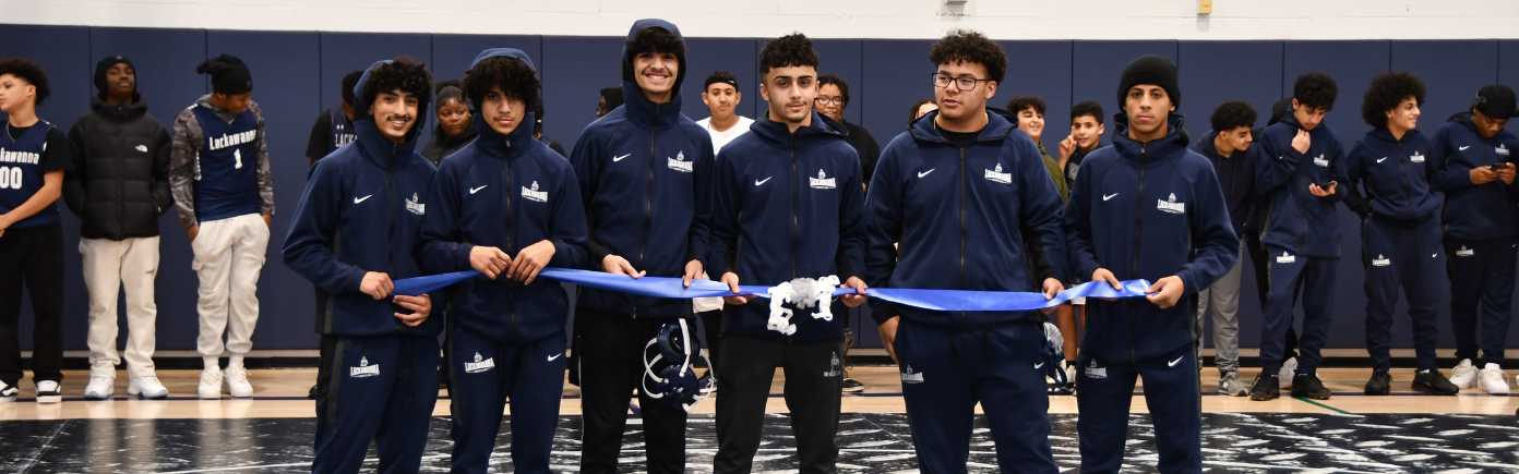 Wrestling team helps open the new gym with a ribbon cutting.