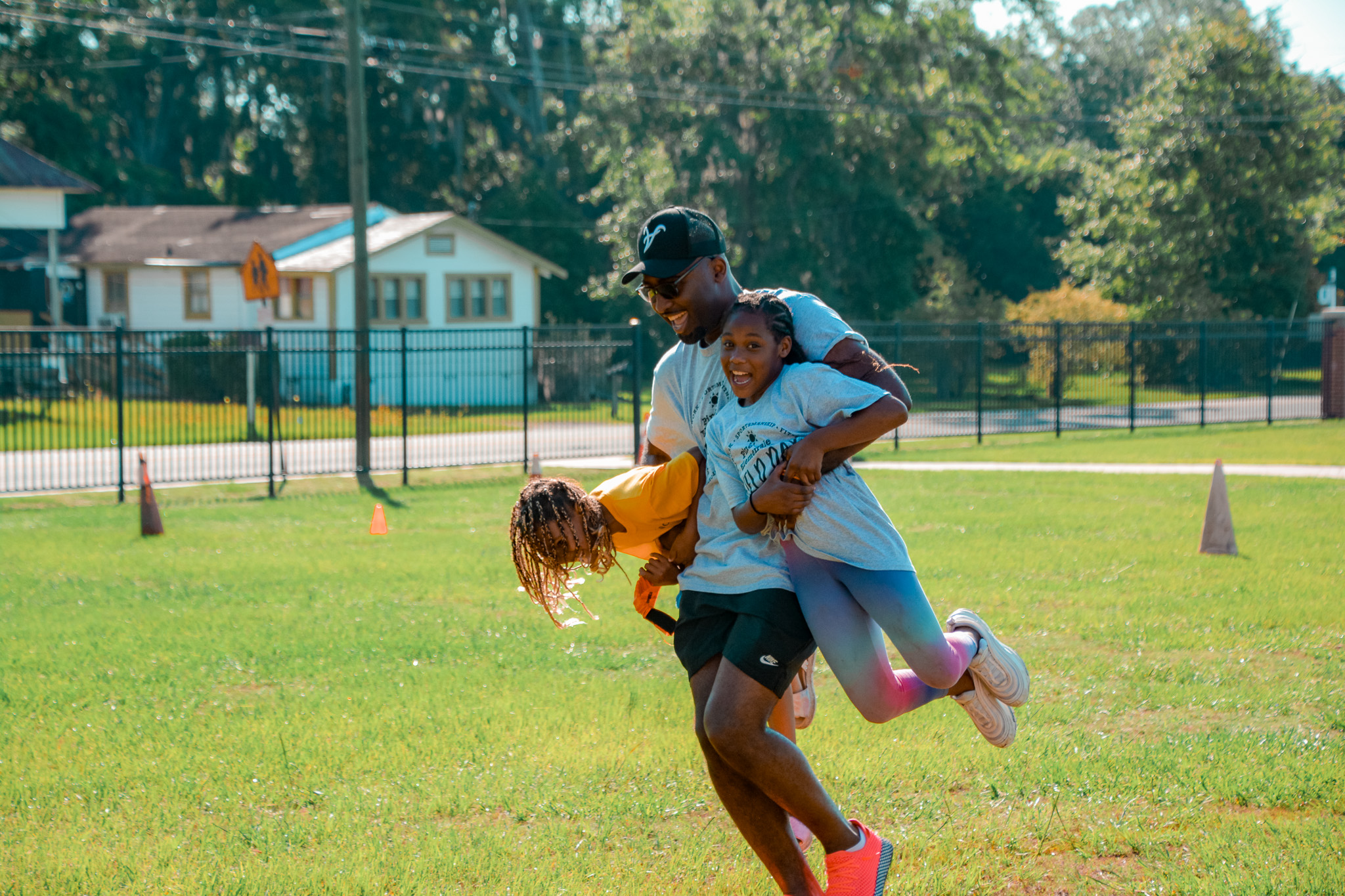 Teacher carrying students during a game at field day