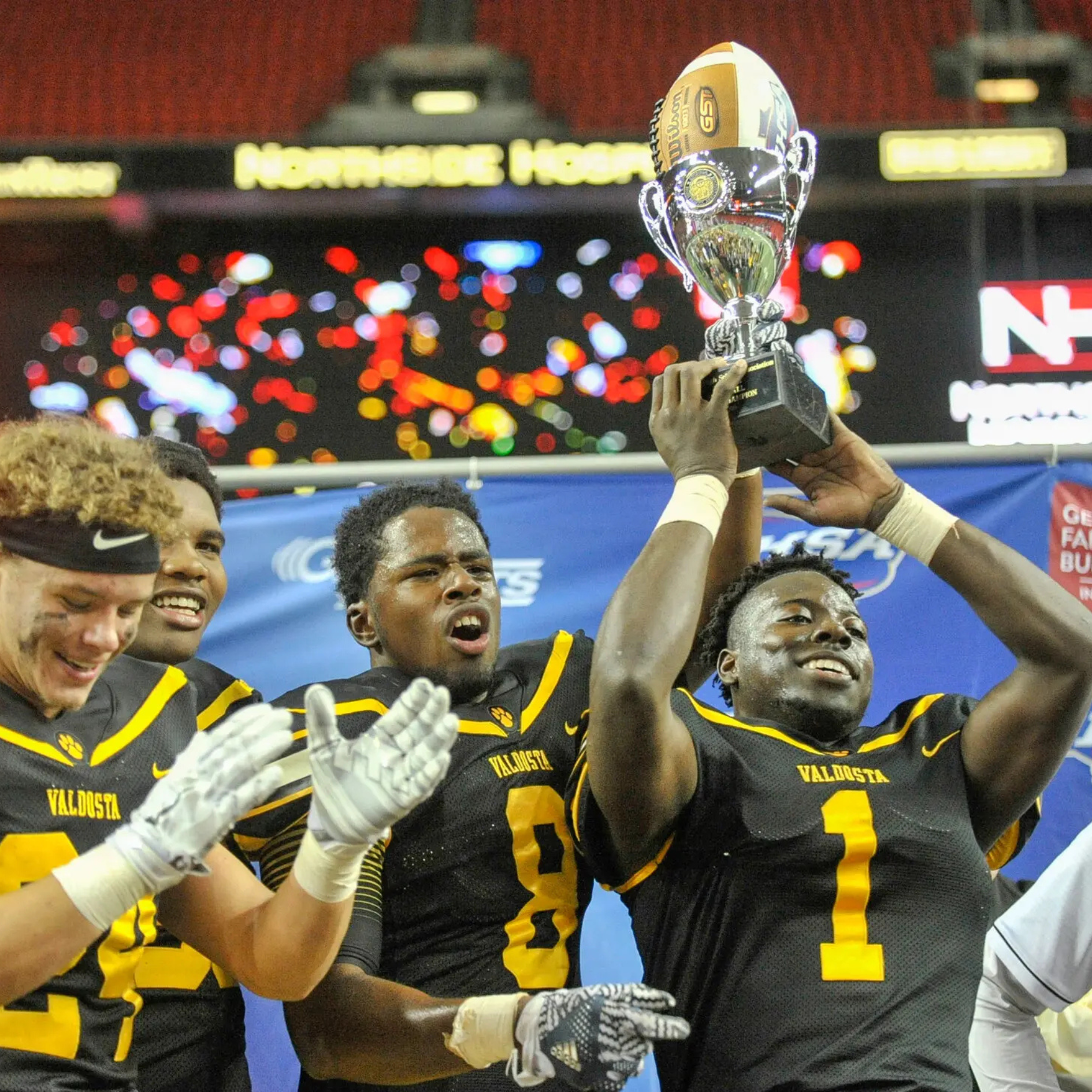 Football player holding championship trophy