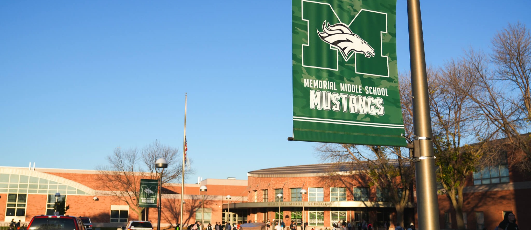 Green flag hanging from a light pole that says Memorial Middle School