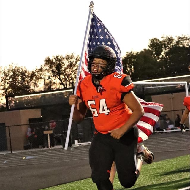 football player holding flag for starting lineups