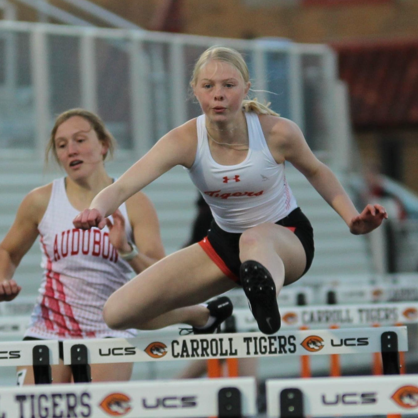 girl jumping over hurdle