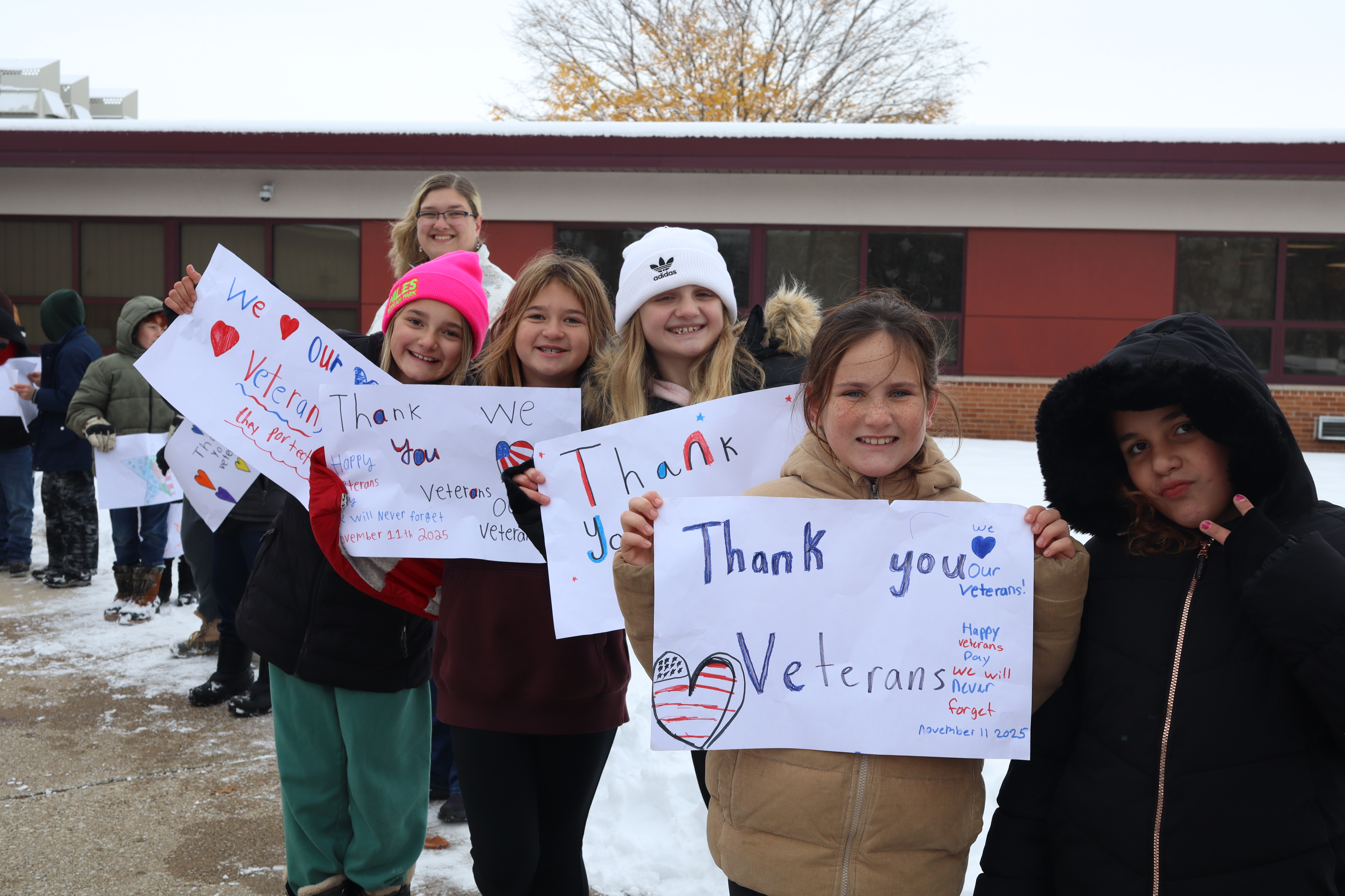 kid standing with veterans signs