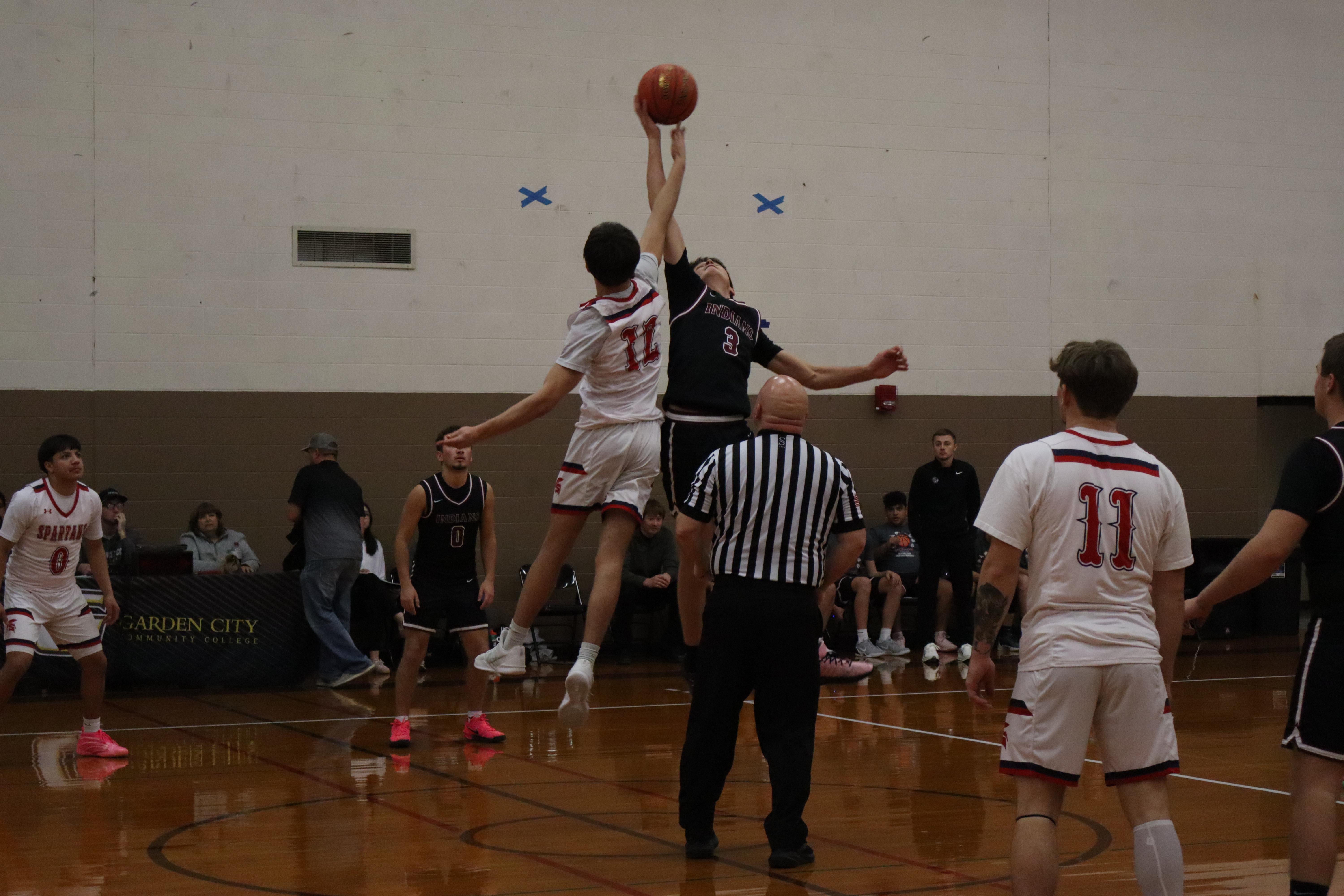 HS basketball players reaching for a jumpball