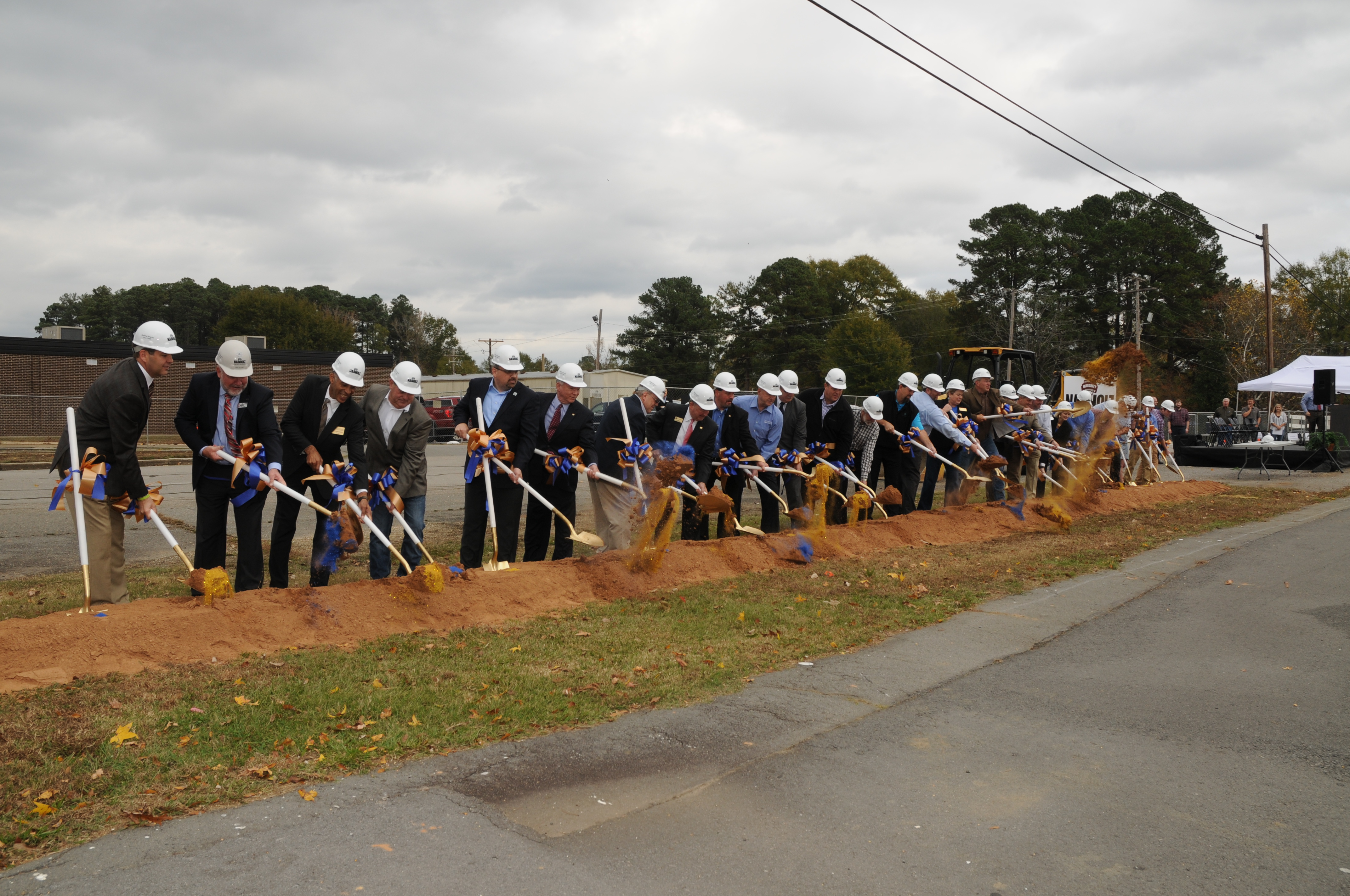 A photo of some people with shovels celebrating the commencement of construction.