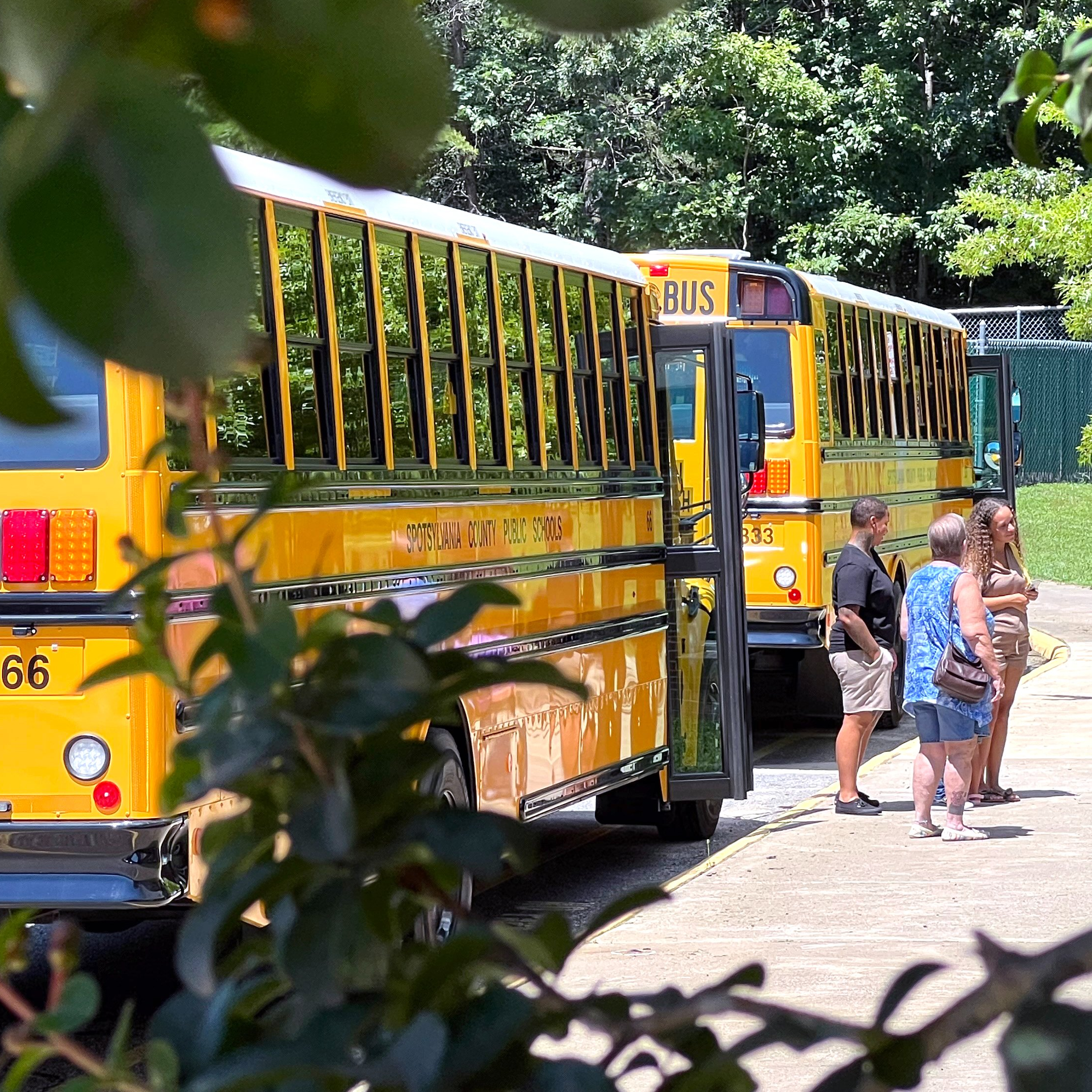 modern school buses parked outside a school