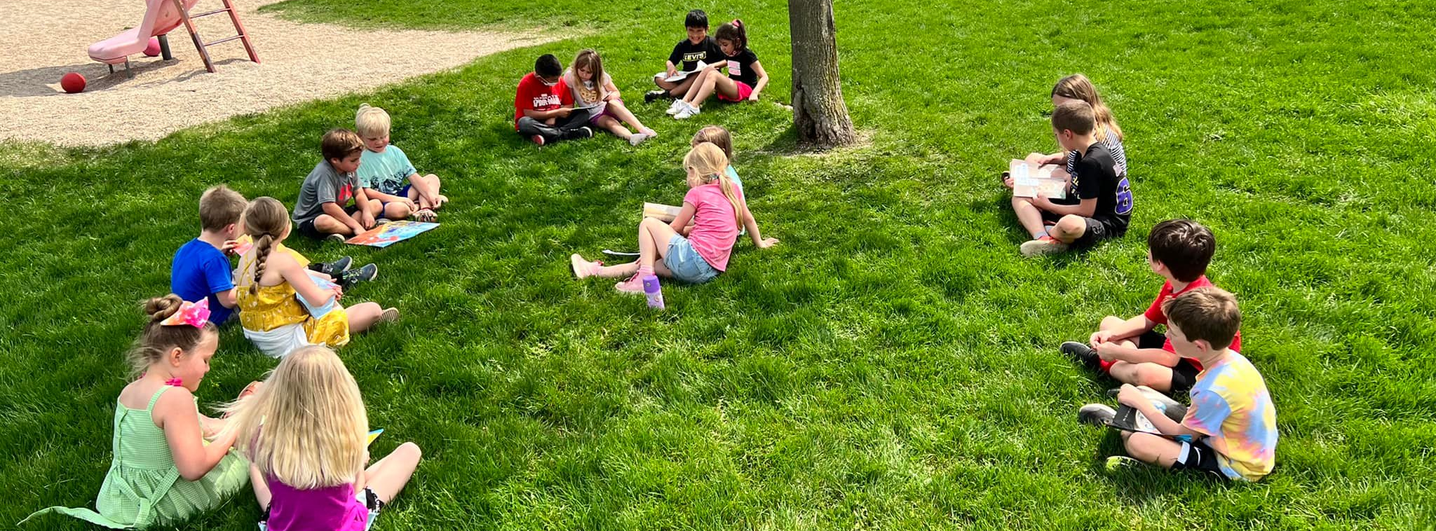 Students sitting on the grass, reading