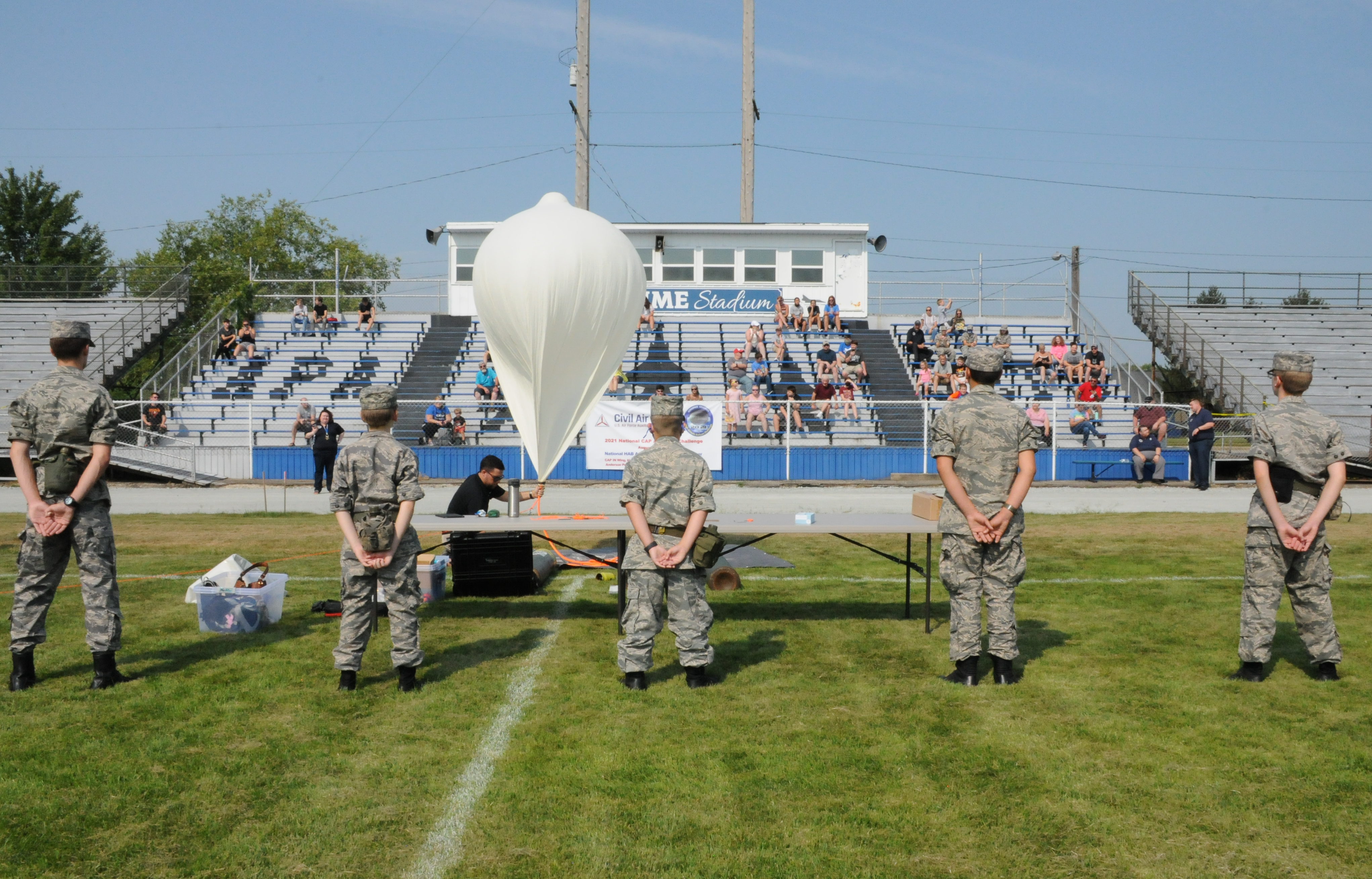 Cadets stand with their backs to the camera with a high-altitude weather balloon. 