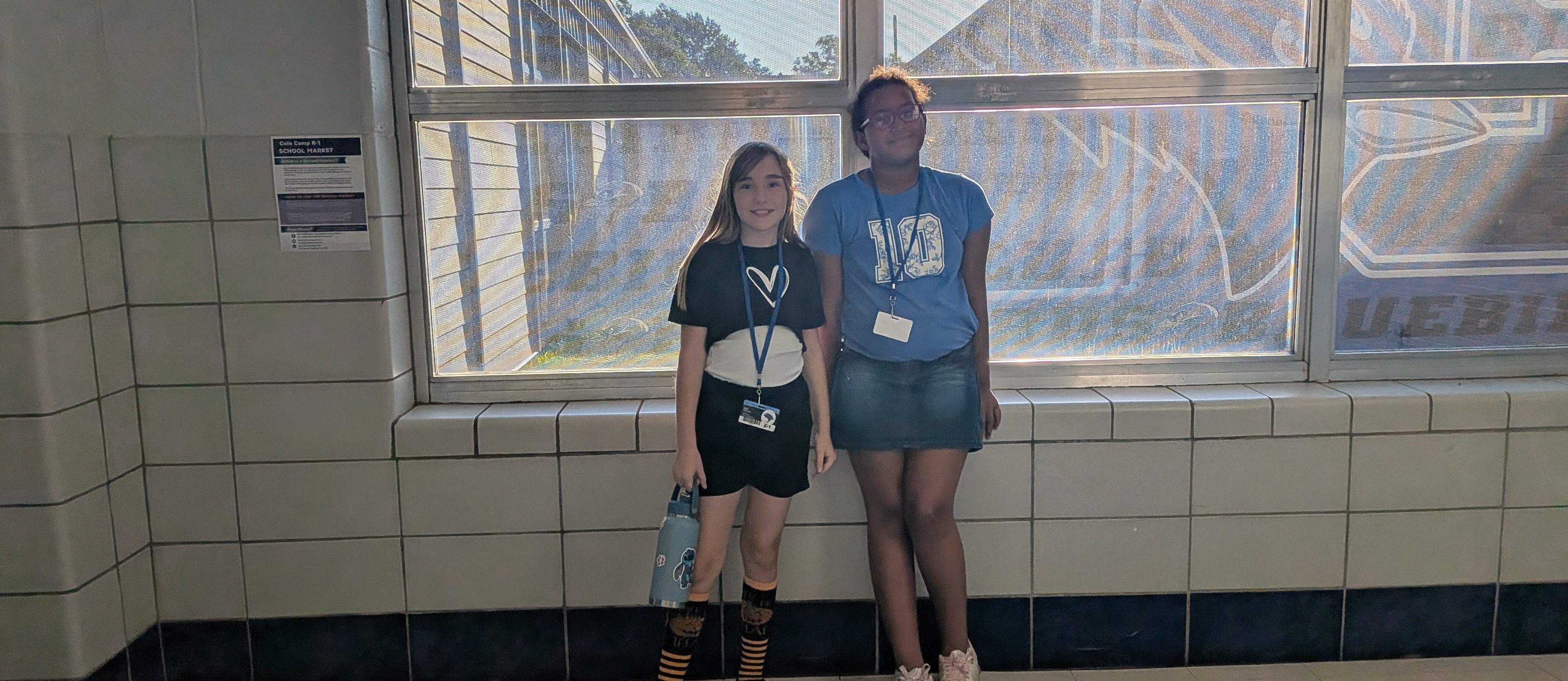 Elementary students standing in front of window on their way to class.