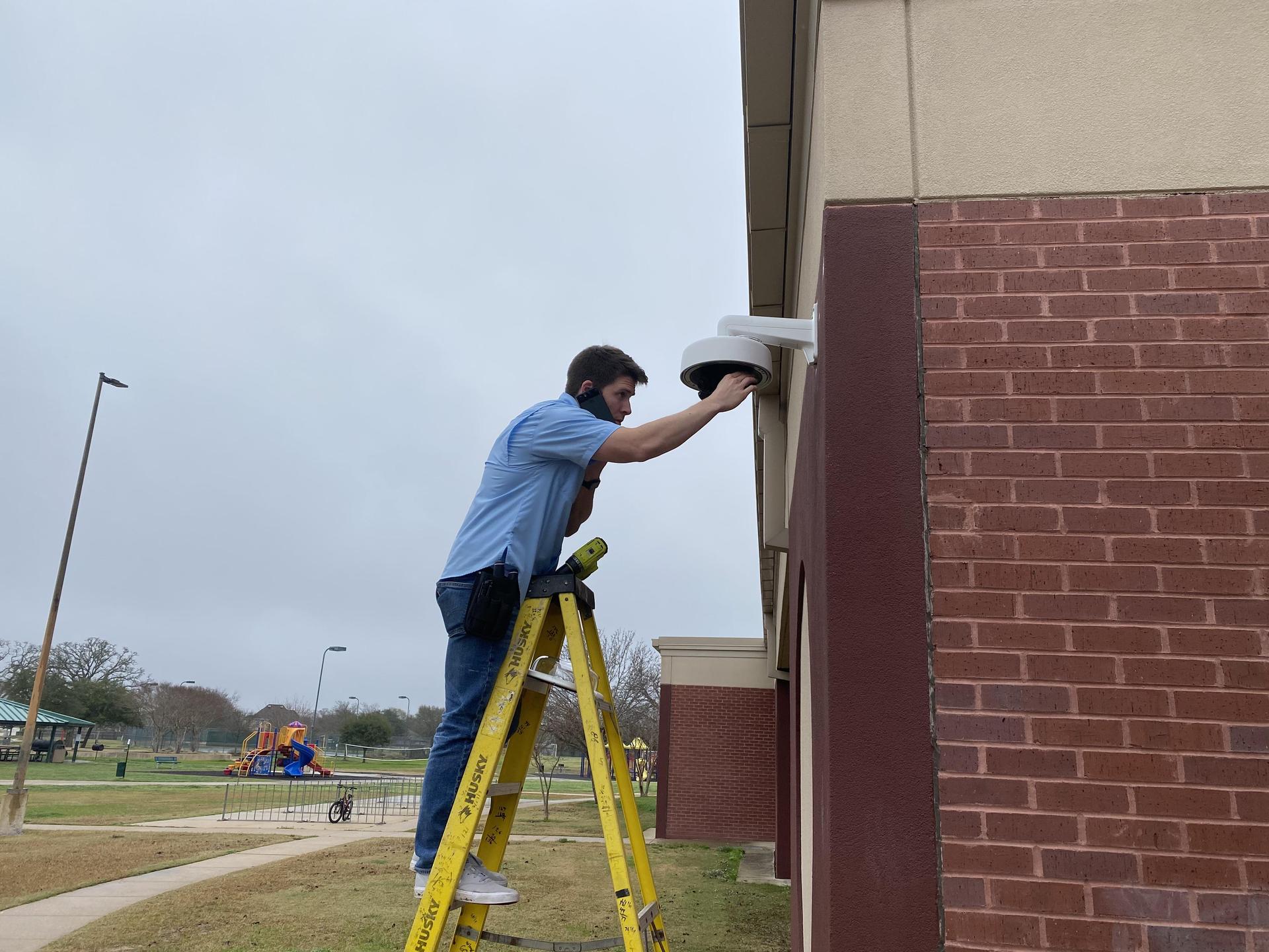 A man installing an exterior camera