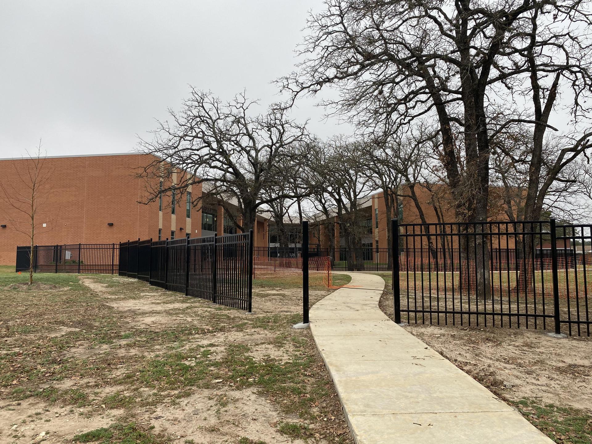 A schoolyard with an iron fence