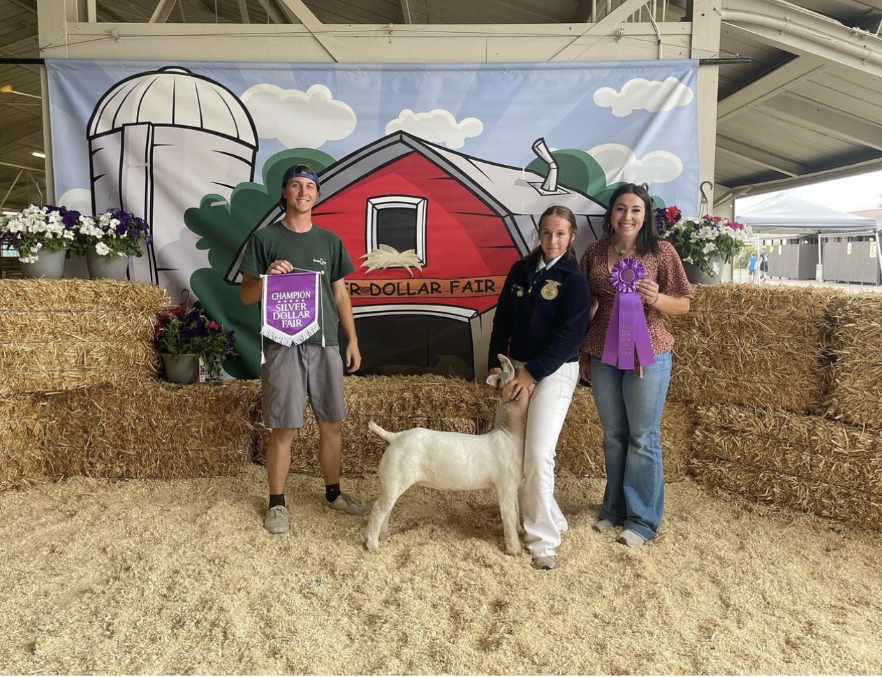 Picture of Durham Ag students showing at the fair and holding Champions  Banner 