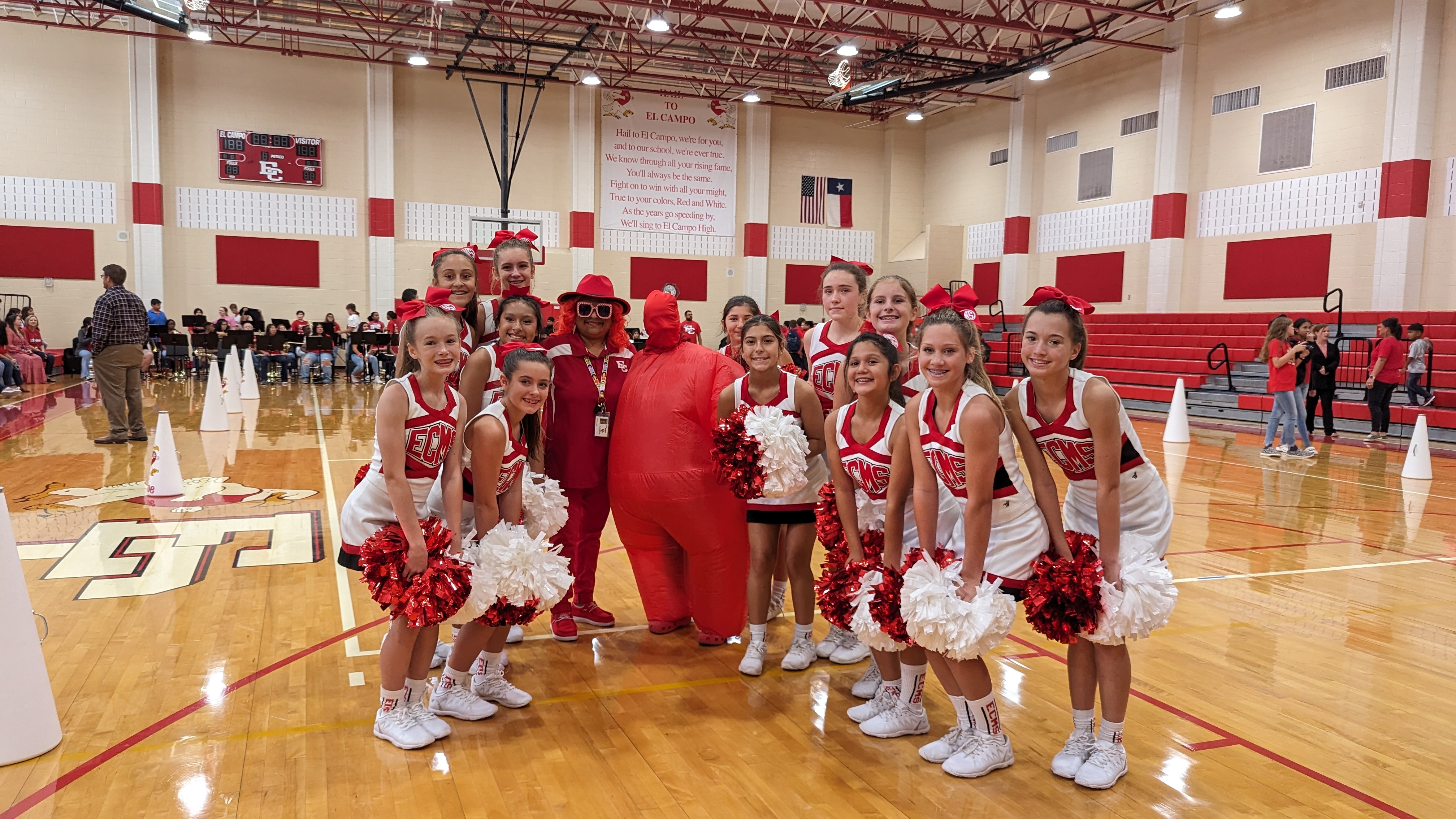 cheerleaders at pep rally with teachers in "red out" dress
