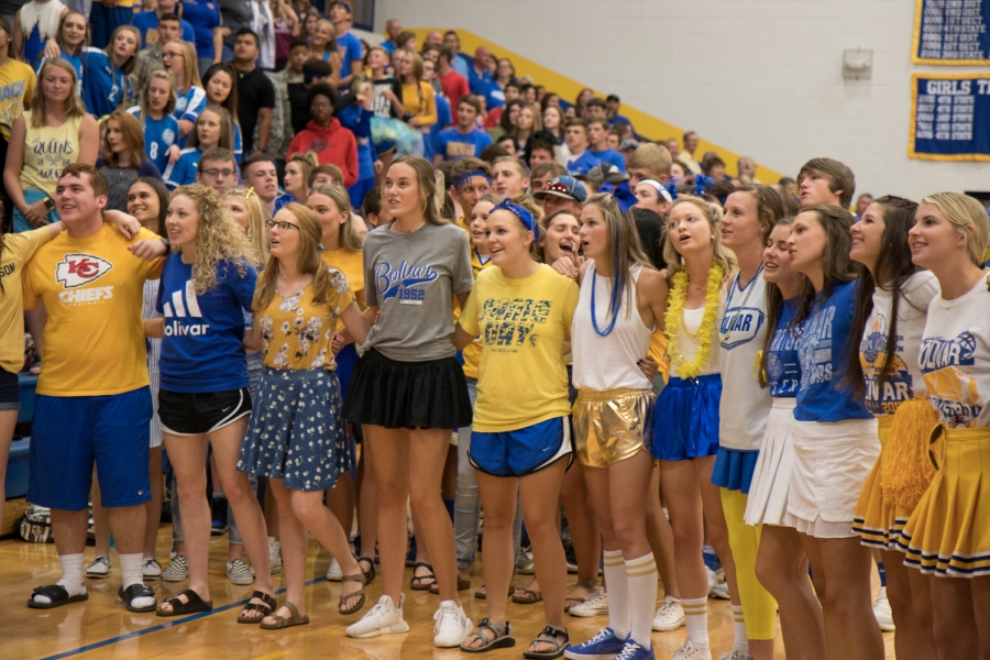 Students singing the school song at an event in the gym