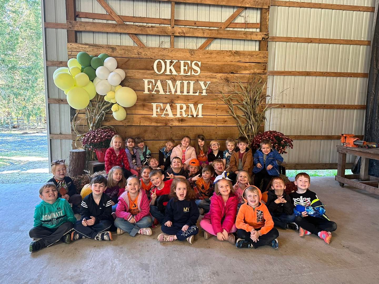 group of students in front of an Okes Family Farm backdrop