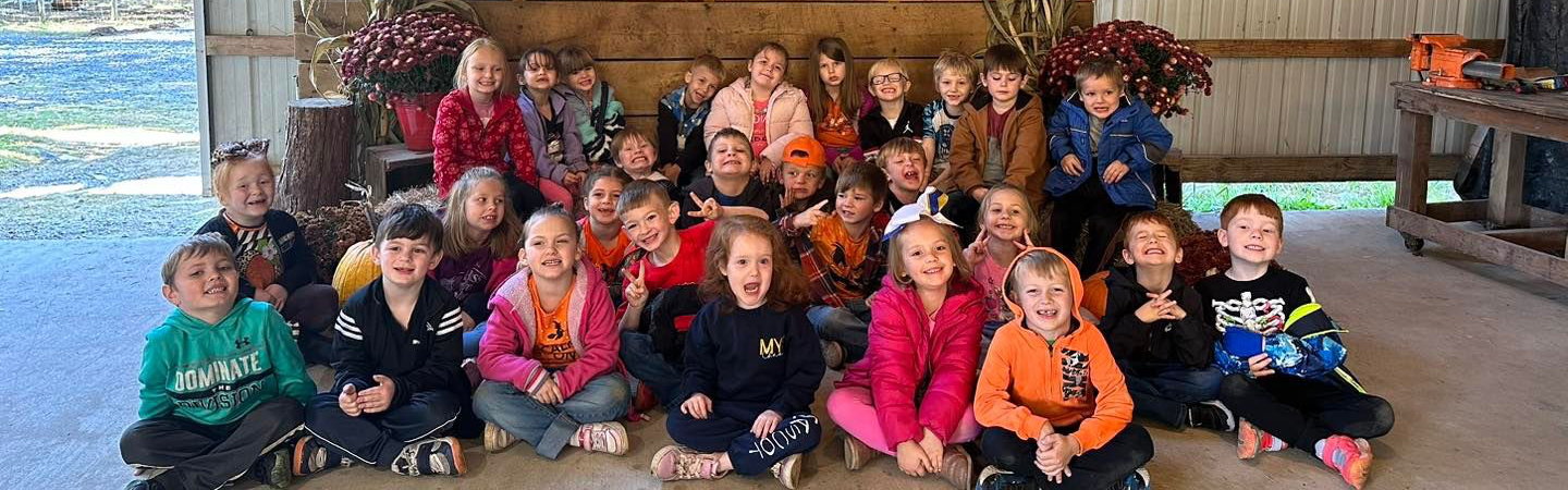 group of students in front of an Okes Family Farm backdrop