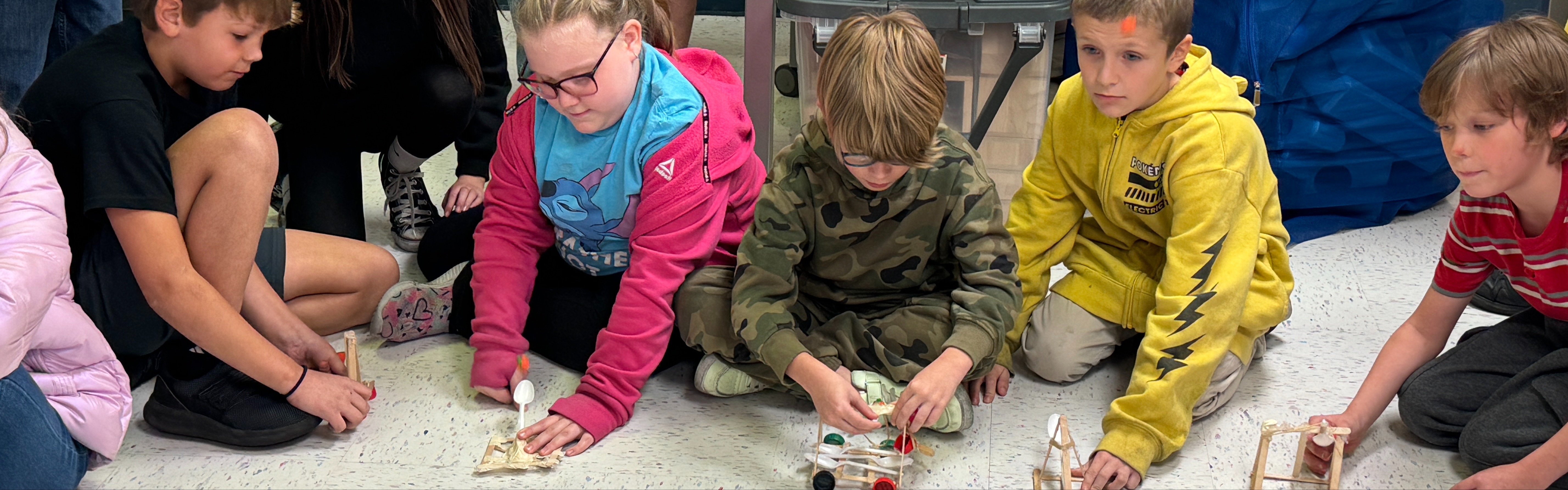A group of students building and launching catapults.