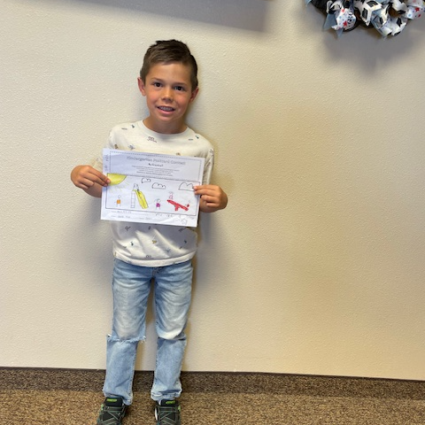kindergarten student holding a drawing he made