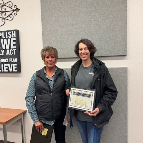 Employee of the Month holding a framed certificate