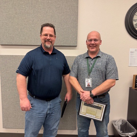 Employee of the Month holding a framed certificate