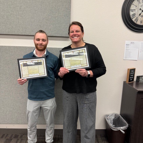 Employee of the Month holding a framed certificate